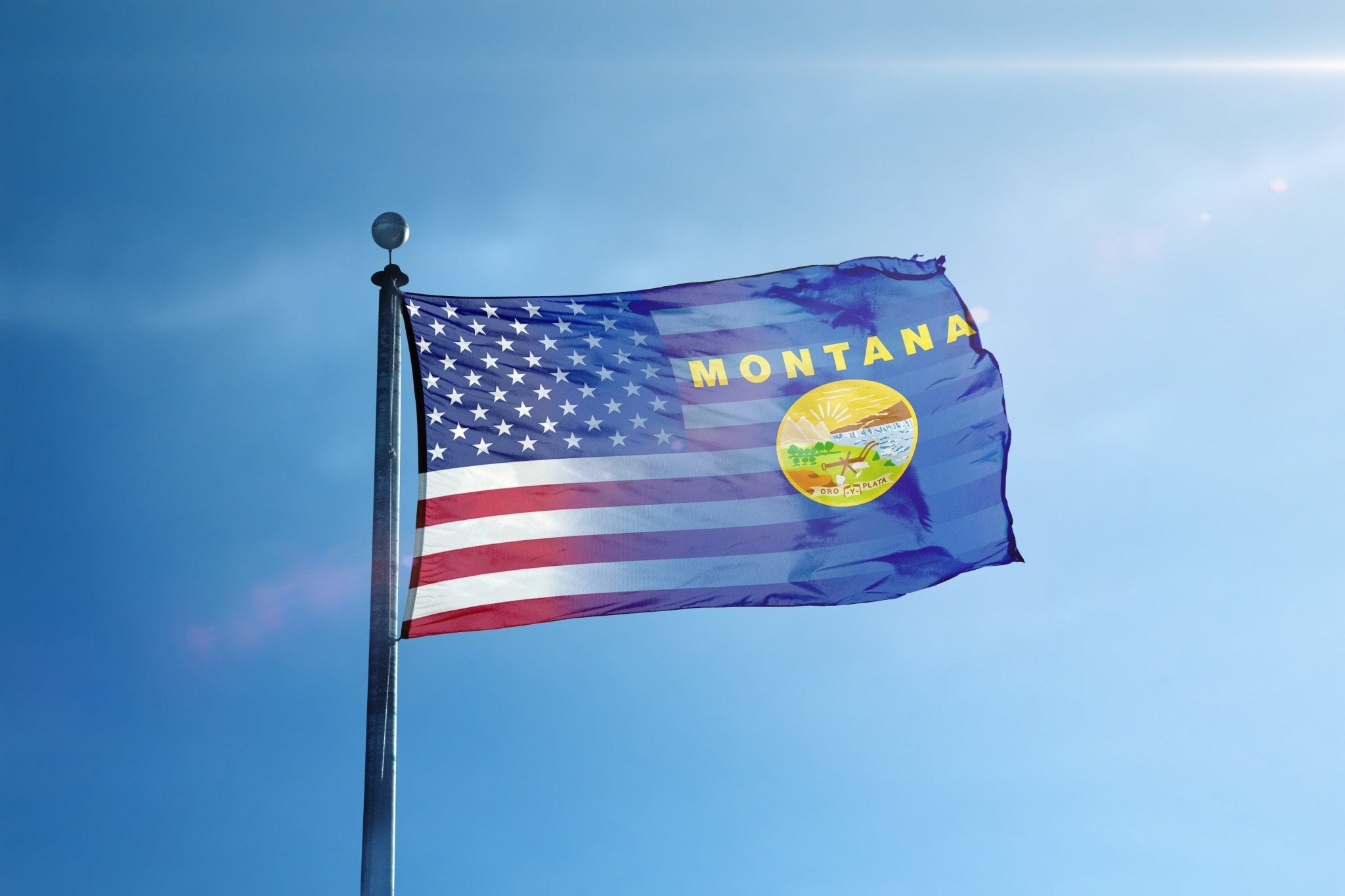 the flag of the state of montana flies high in the blue sky