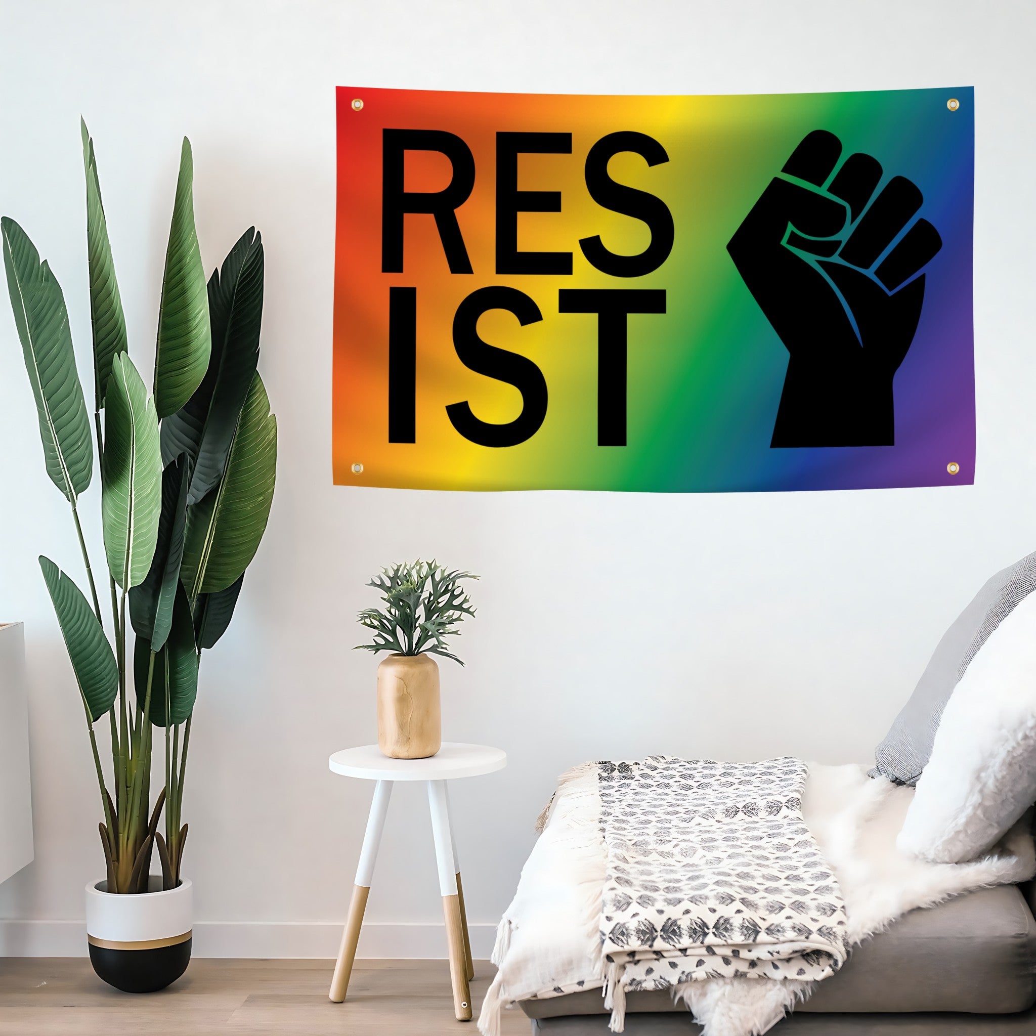 Rainbow flag banner with 'RESIST' and a raised fist in a living room setting.