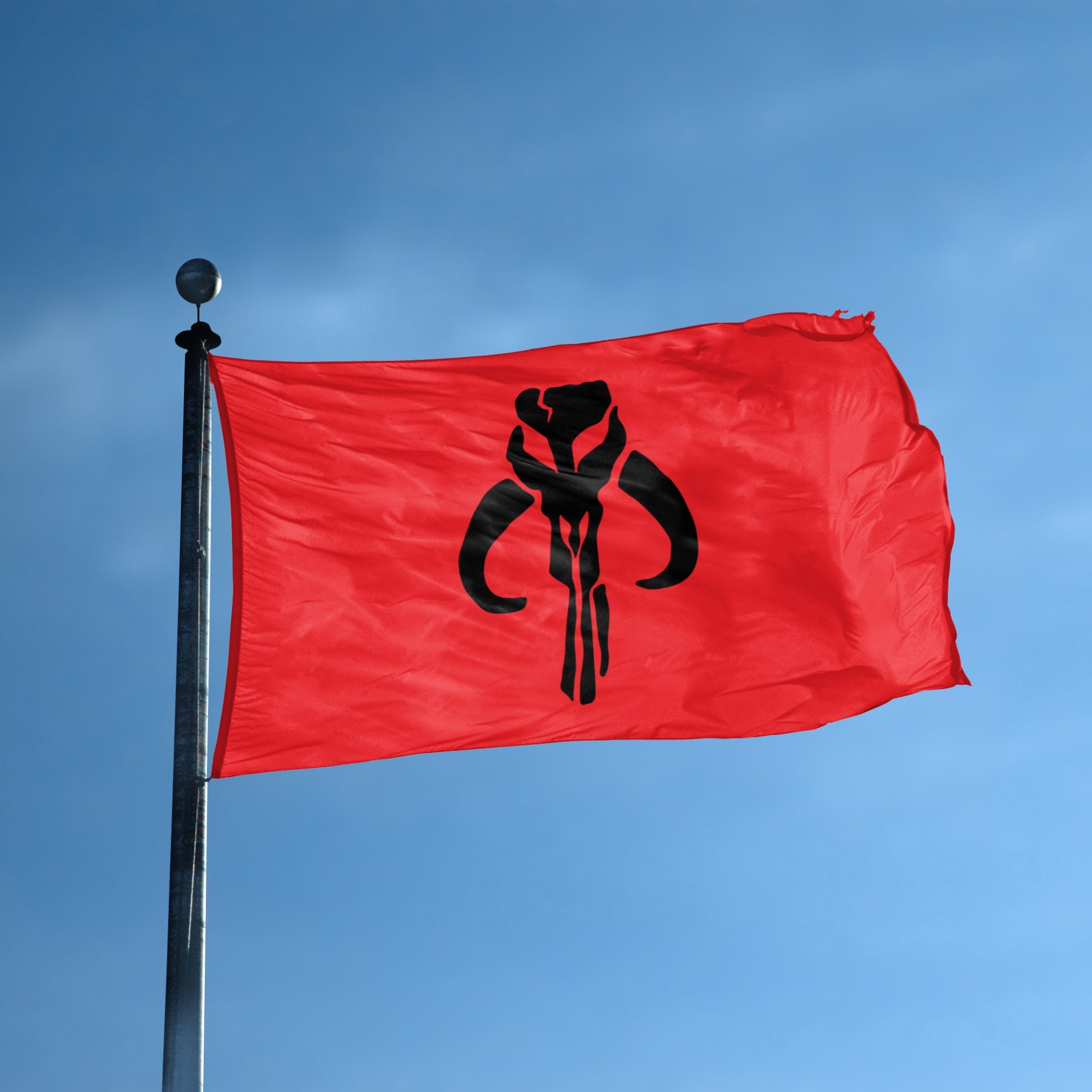 Red flag with a black star wars mandalorian emblem hanging on a pole. 