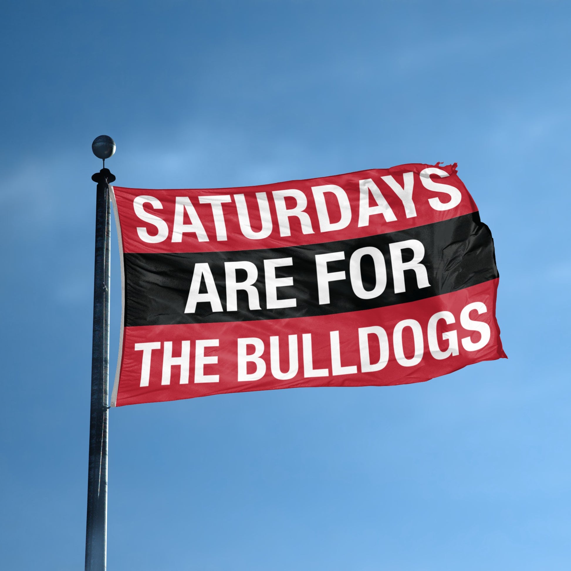 Flag with 'Saturdays are for the Bulldogs' text against a blue sky