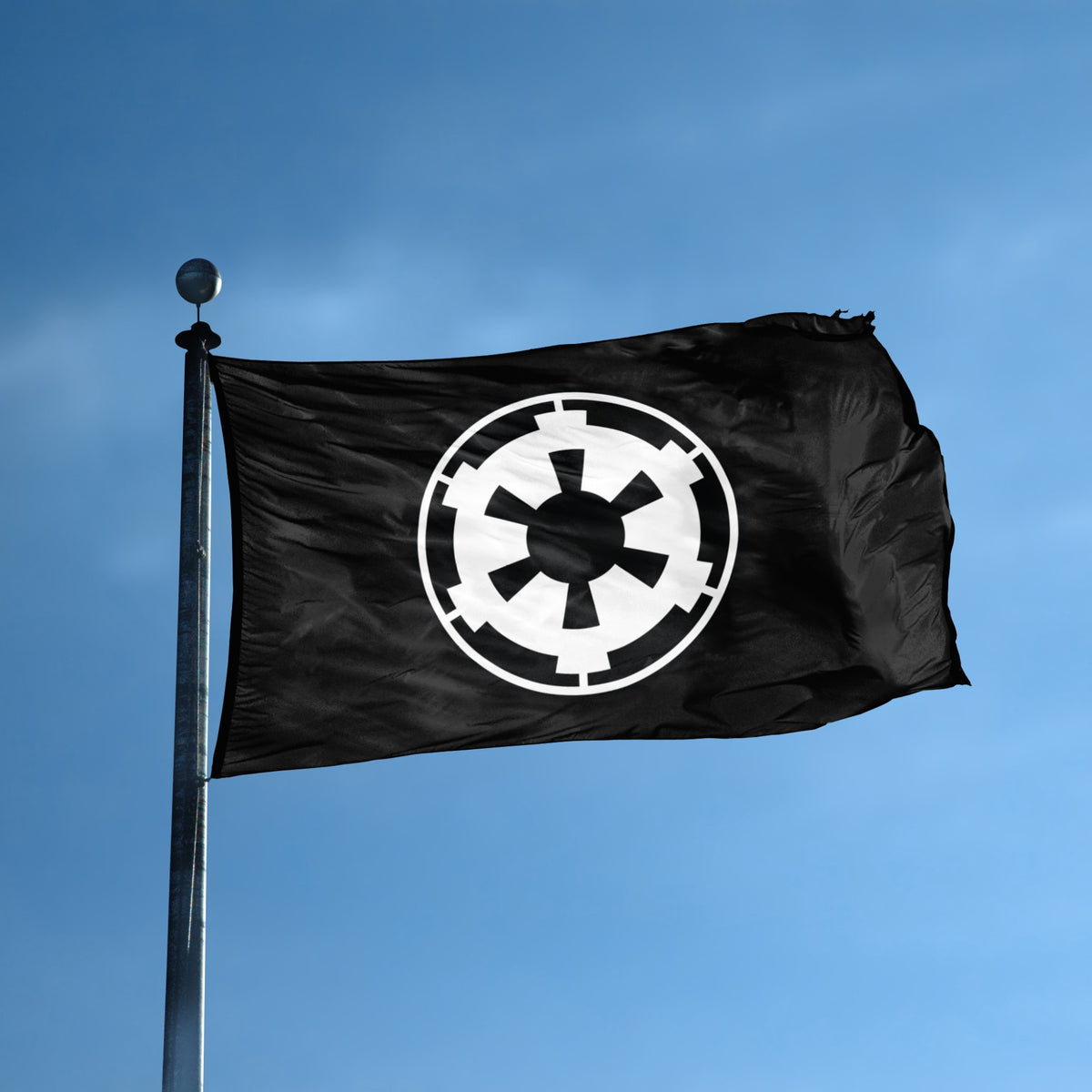 A black flag with a large white Star Wars Galactic Empire Imperial-style emblem waving on a silver flagpole against a clear blue sky.