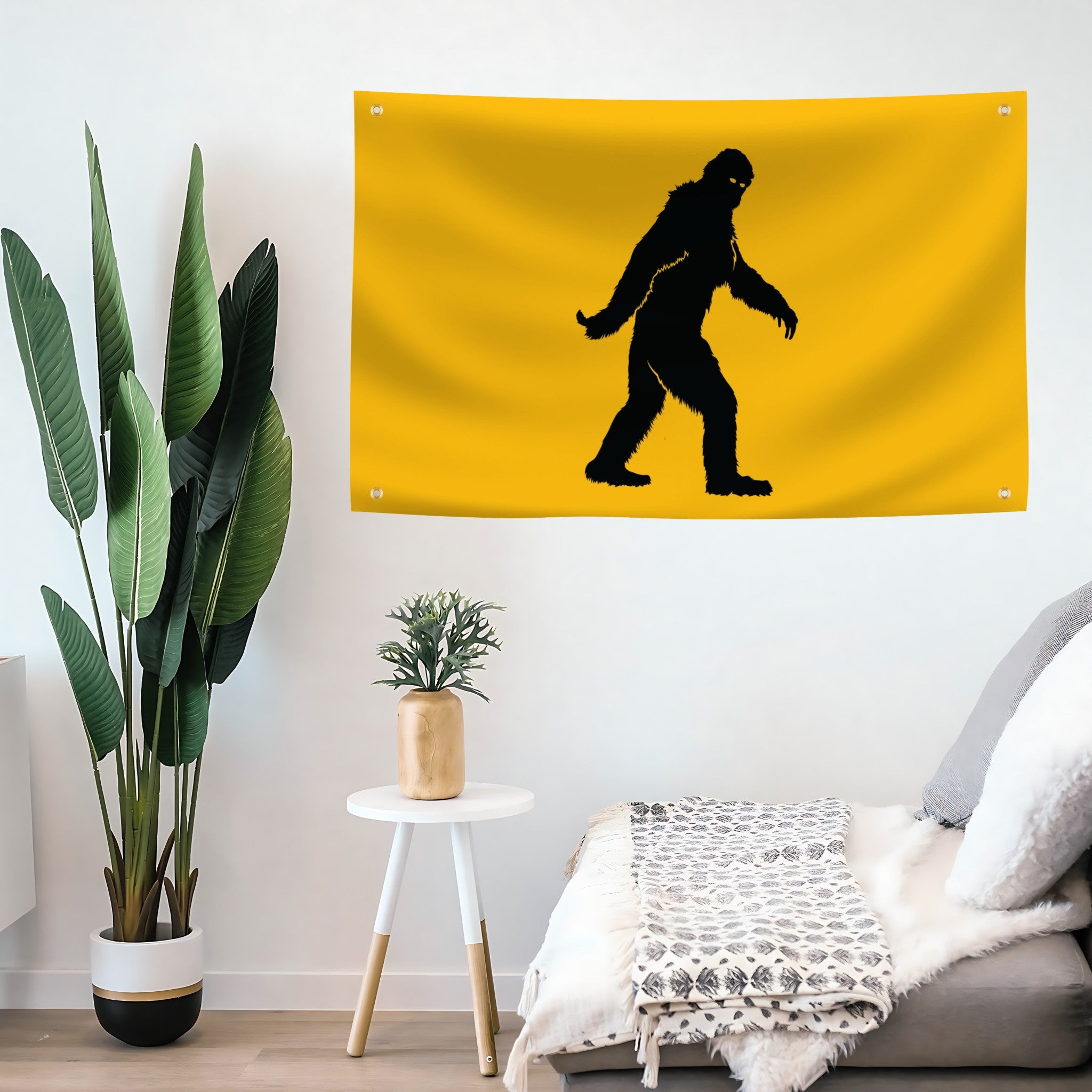 Yellow flag with black silhouette of bigfoot on a wall in a living room.