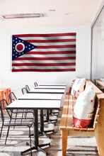 Load image into Gallery viewer, a long table with chairs and a flag hanging on the wall
