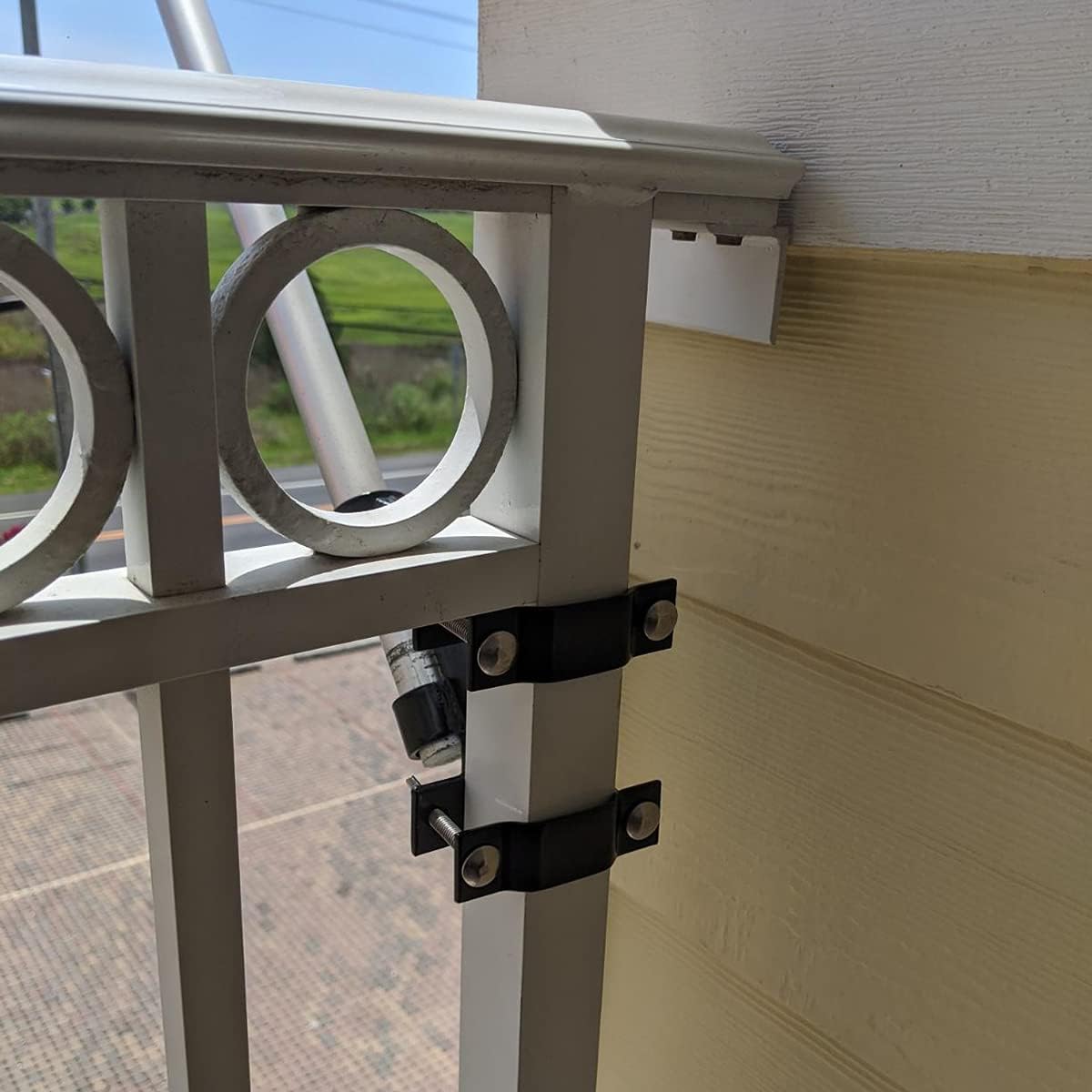 Flag pole mount clamp installed on apartment balcony railing showing secure outdoor flag display setup
