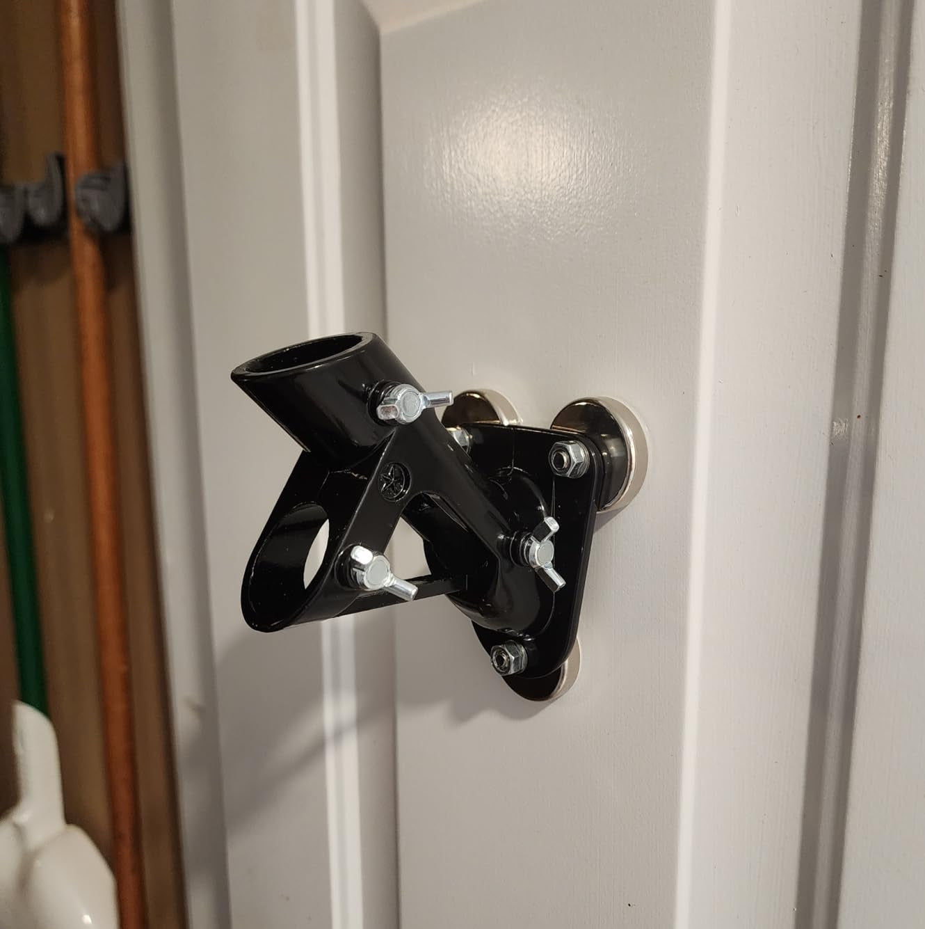 Black flag pole wall mount bracket installed on white exterior wall demonstrating secure outdoor mounting