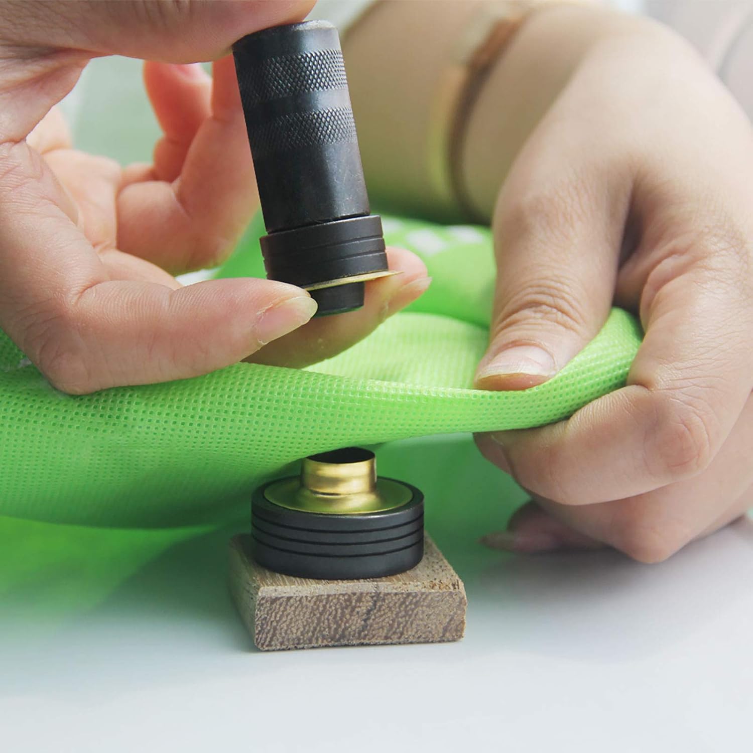 Installing brass grommets on a polyester flag using a grommet press tool