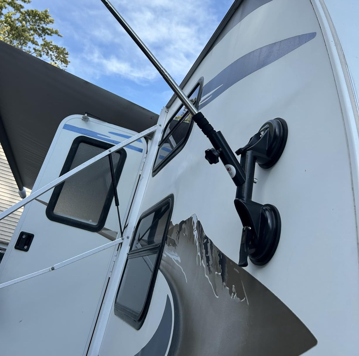 Flag pole suction cup mount attached to RV exterior displaying American flag for camping and travel flag display