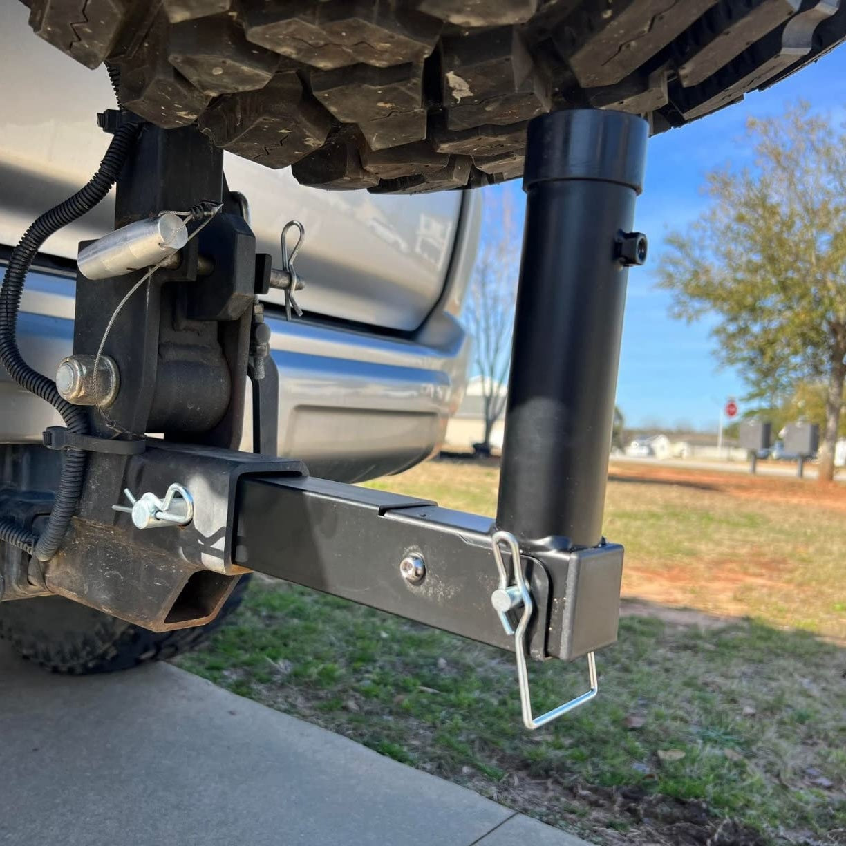 Close-up of a vehicle flag pole hitch on a truck clearing the spare tire