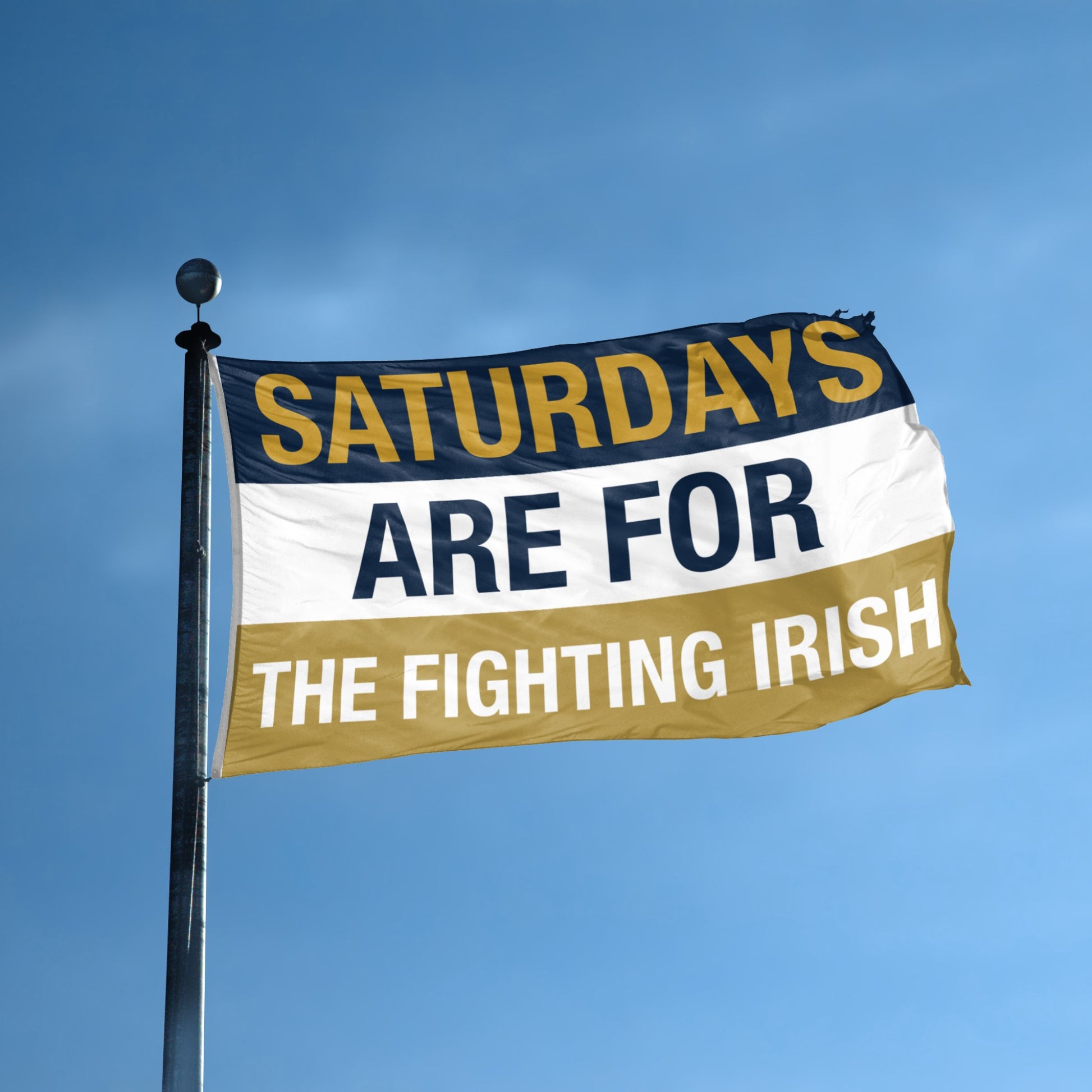 Flag with 'Saturdays are for the Fighting Irish' text against a blue sky