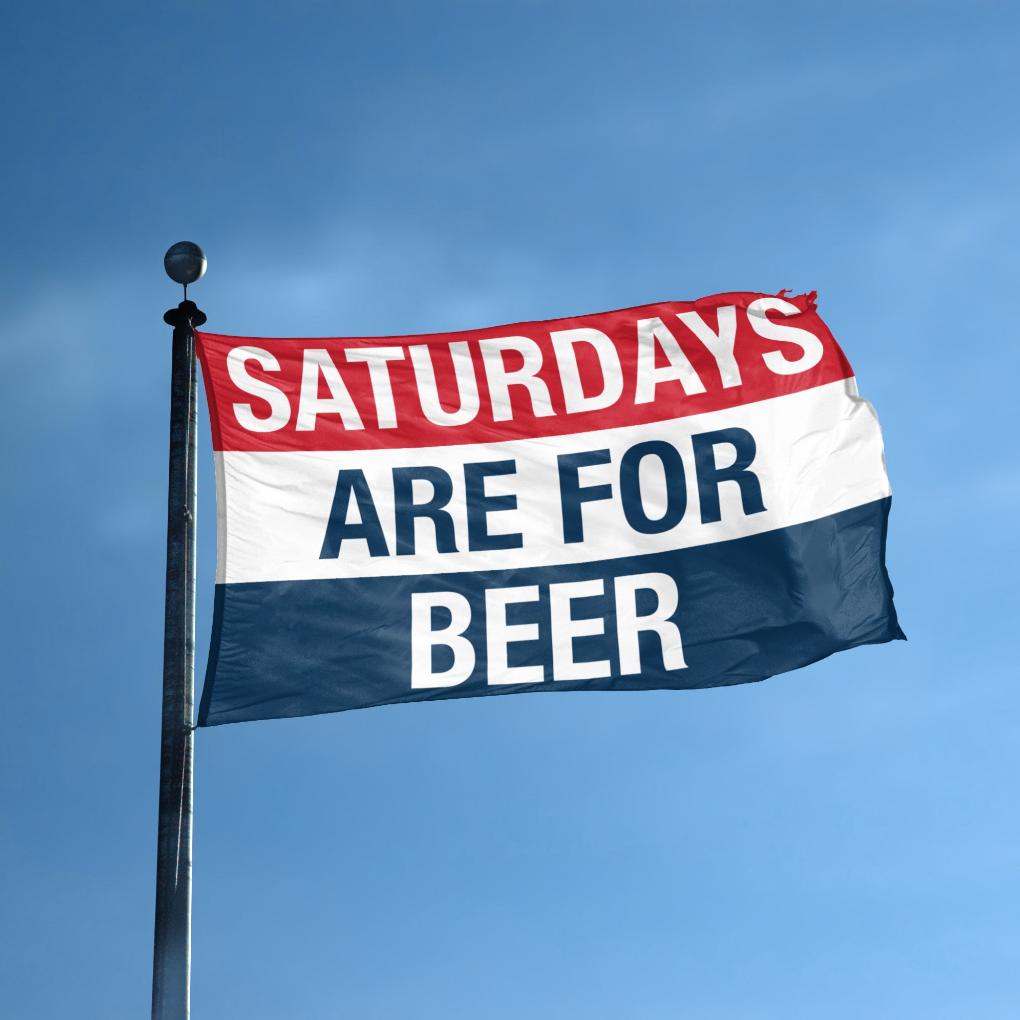 Flag with 'Saturdays are for Beer' text against a blue sky on a flag pole.