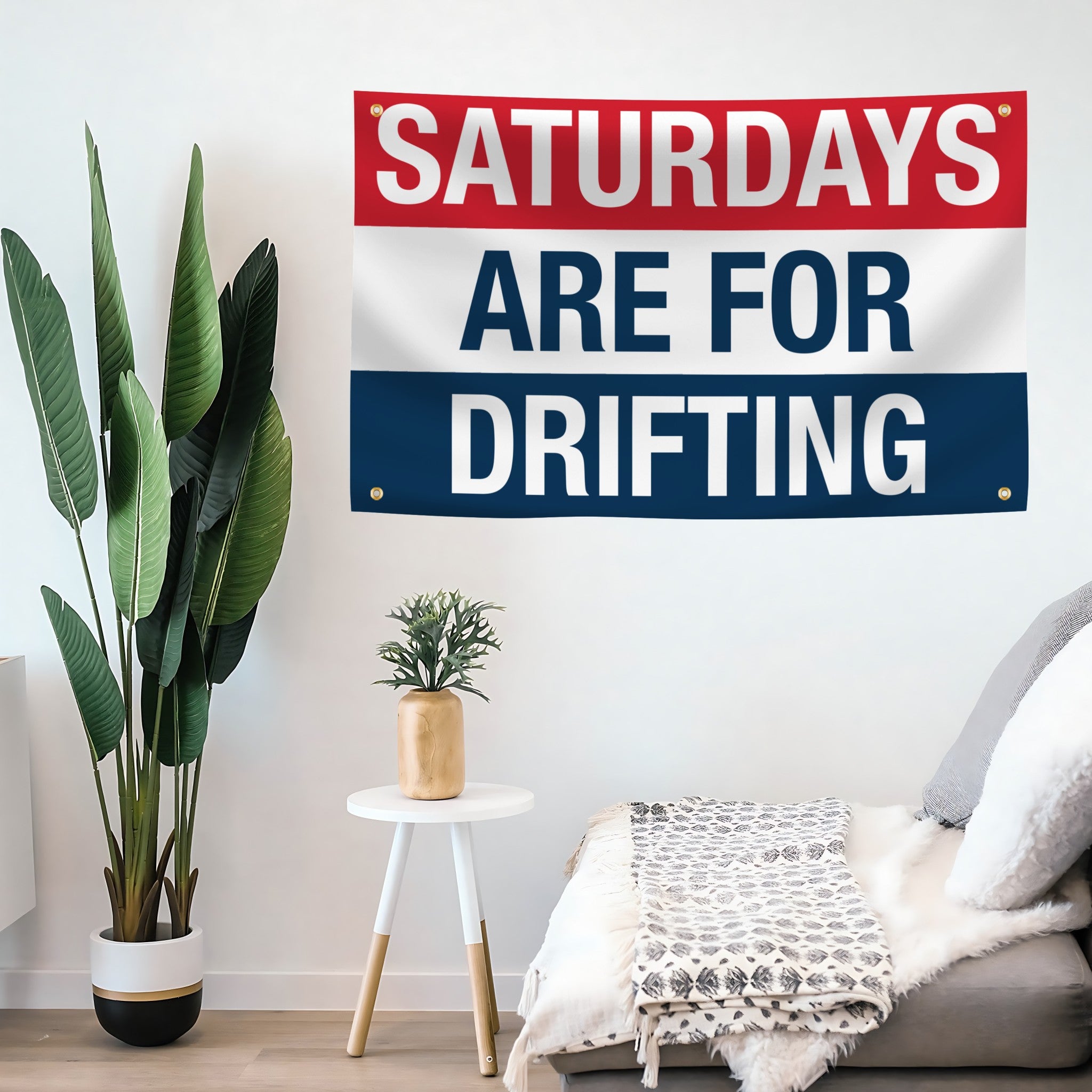 Decorative flag banner with 'Saturdays are for Drifting' text in a room with plants and furniture.