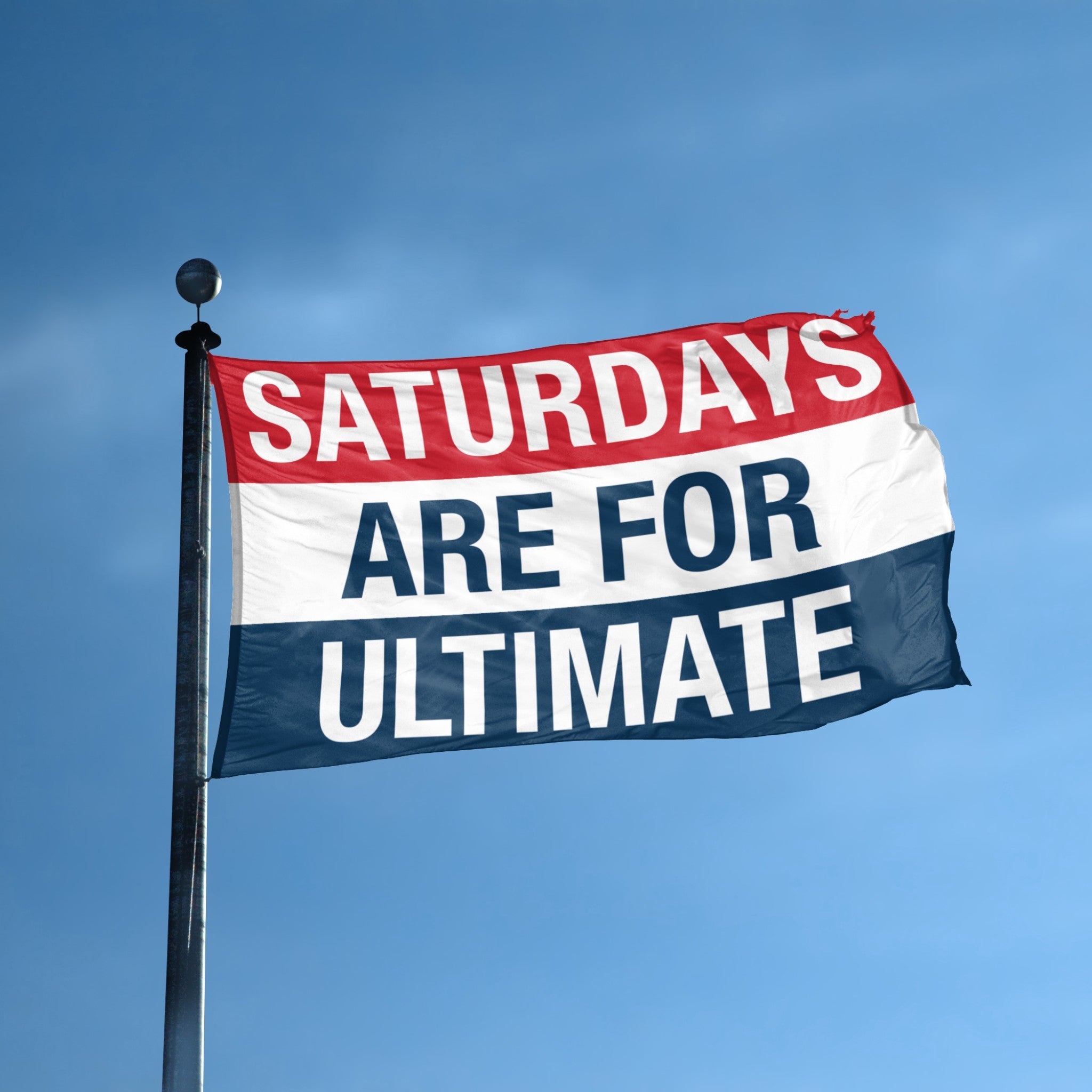 Flag with 'Saturdays are for Ultimate' text against a blue sky