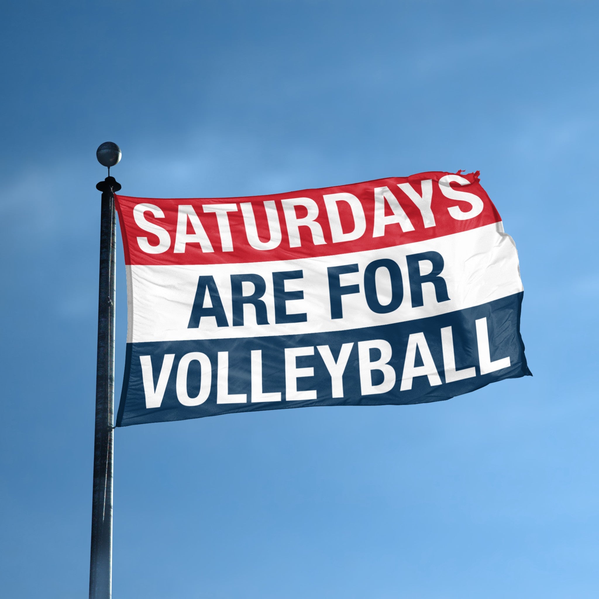 Flag with 'Saturdays are for Volleyball' text against a blue sky