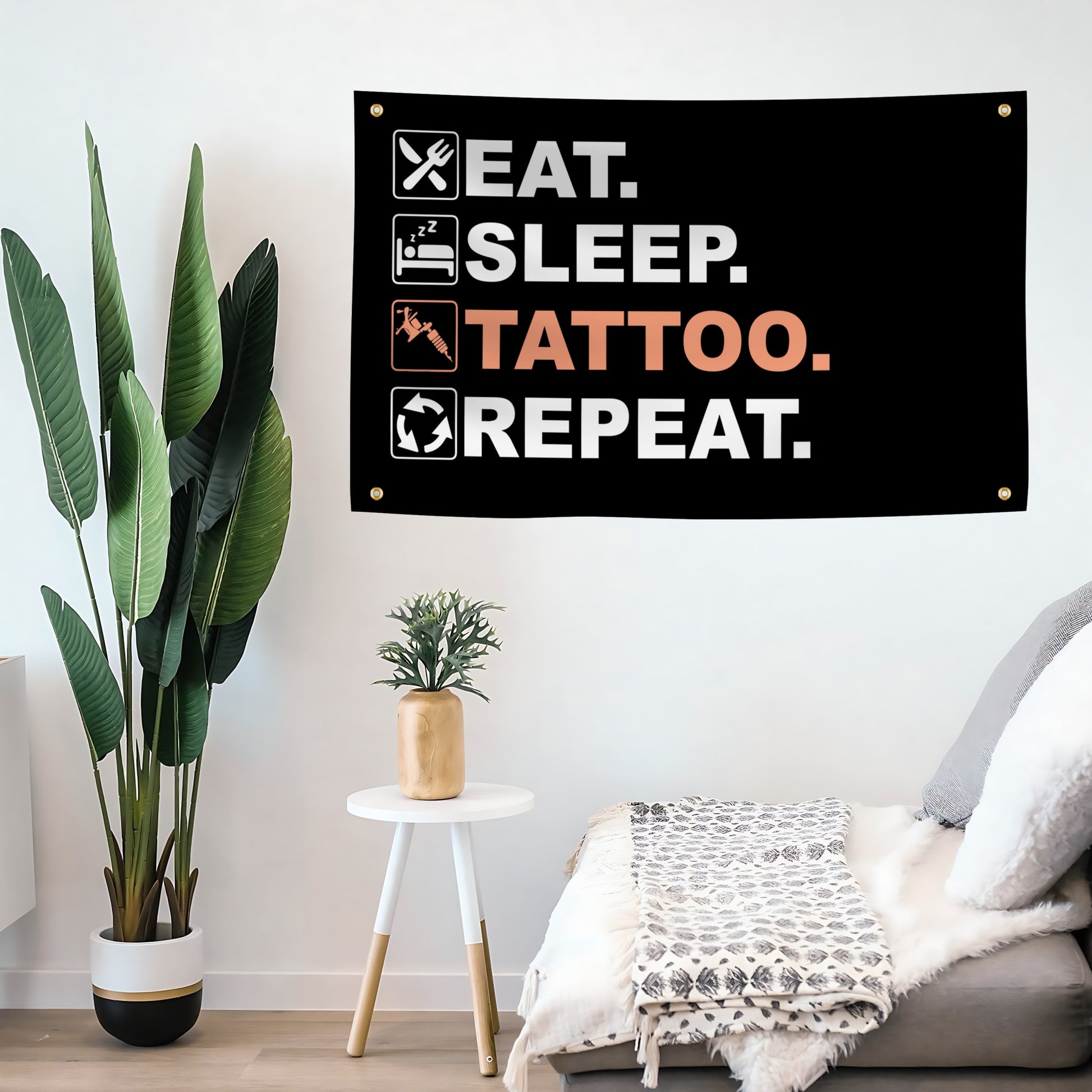 Decorative banner with 'Eat. Sleep. Tattoo. Repeat.' text in a living room setting.