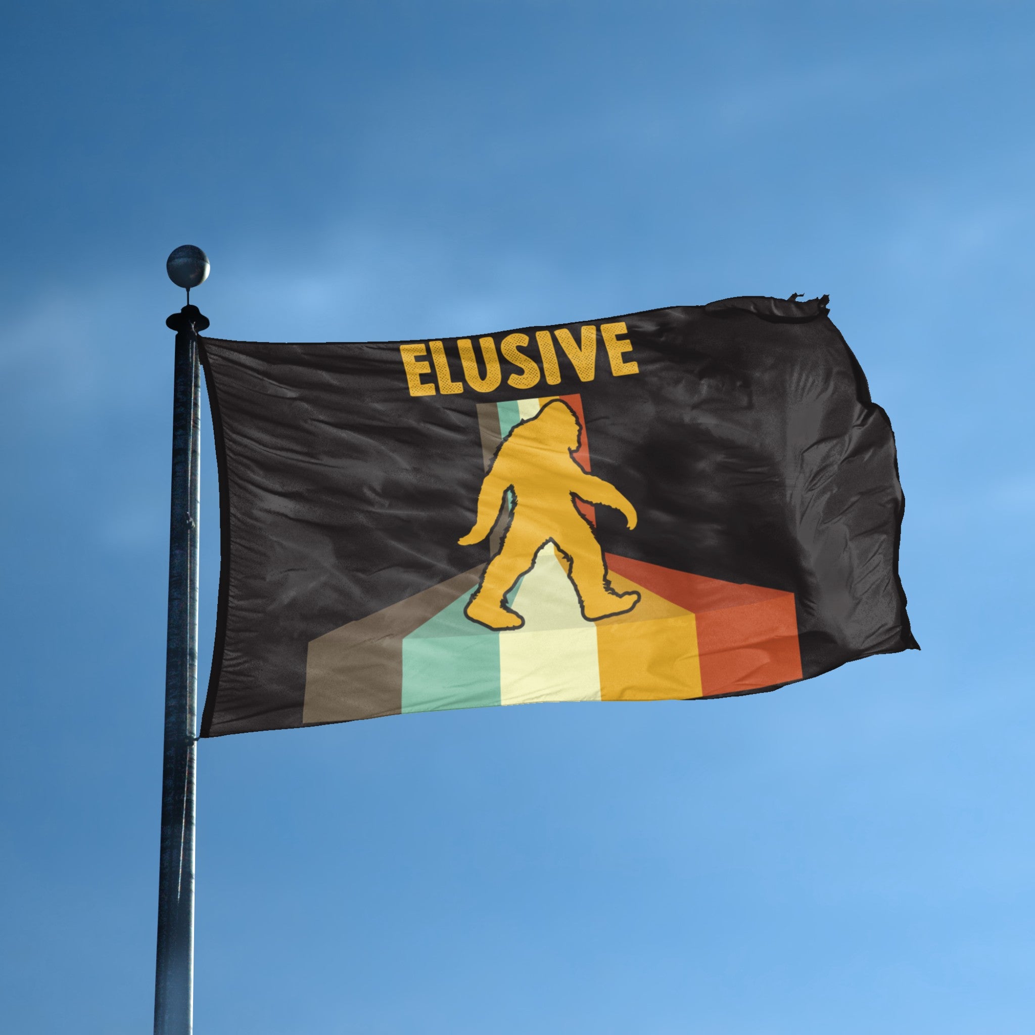 A flag with the theme "Bigfoot Elusive" displayed on a tall flag pole and blue skies.