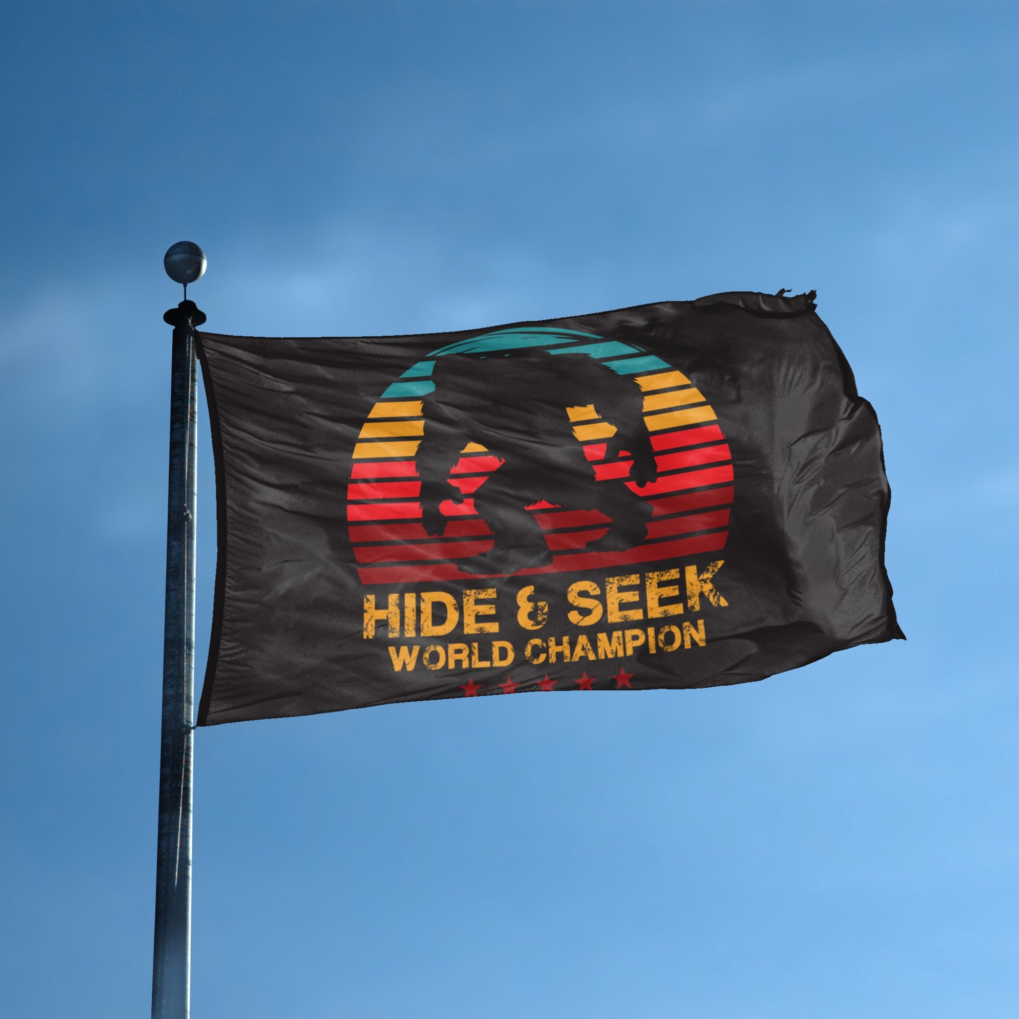 A flag with the theme "Bigfoot Hide & Seek World Champion" displayed on a tall flag pole and blue skies.