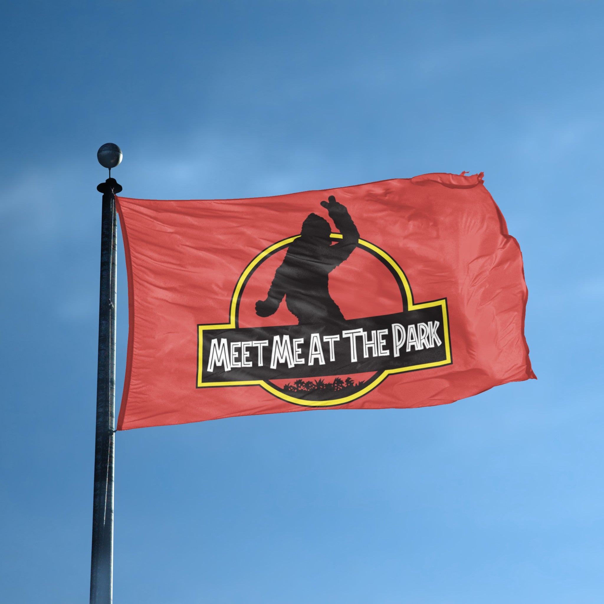 A flag with the theme "Bigfoot Meet Me At The Park Parody" displayed on a tall flag pole and blue skies.