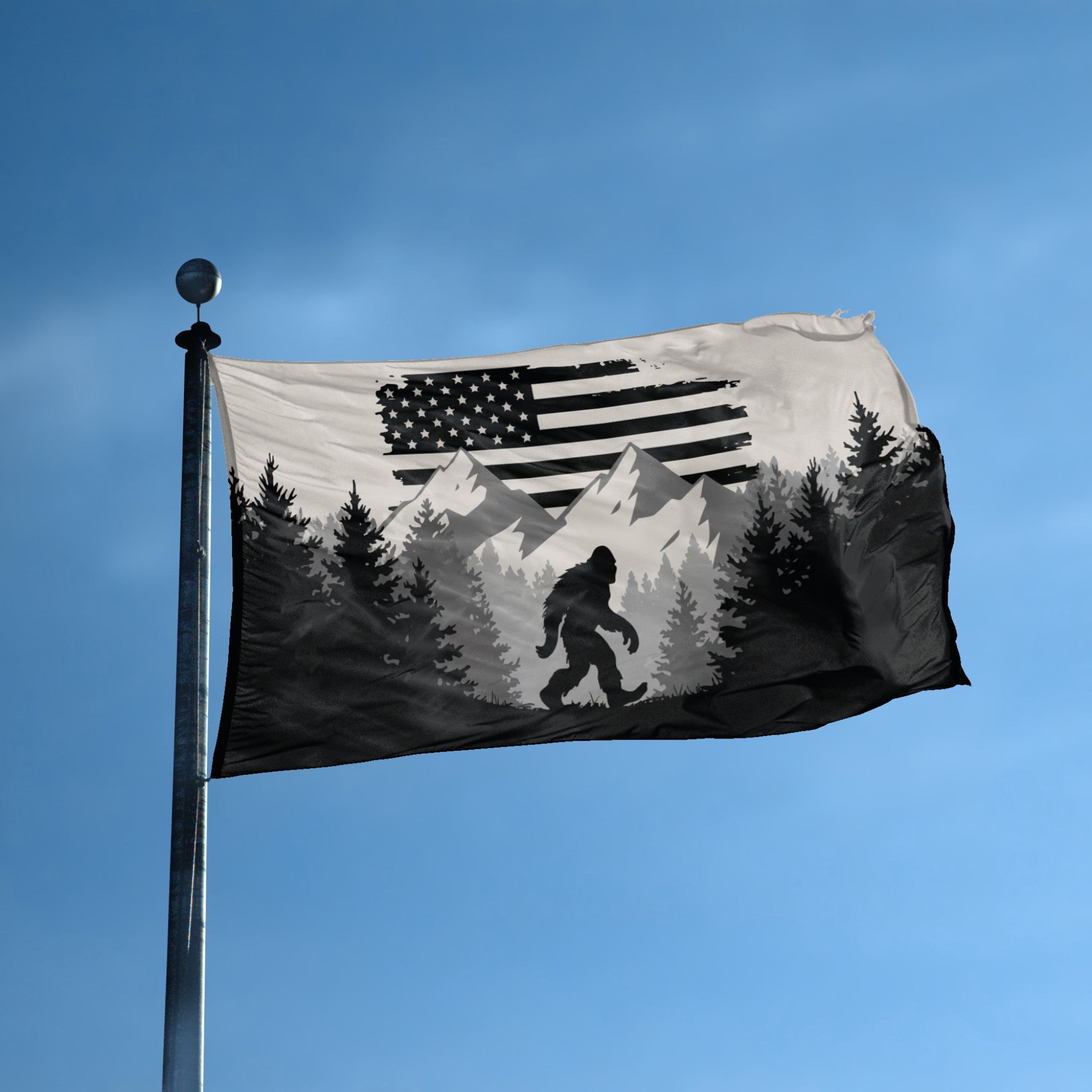 A flag with the theme "Bigfoot Mountains American" displayed on a tall flag pole and blue skies.