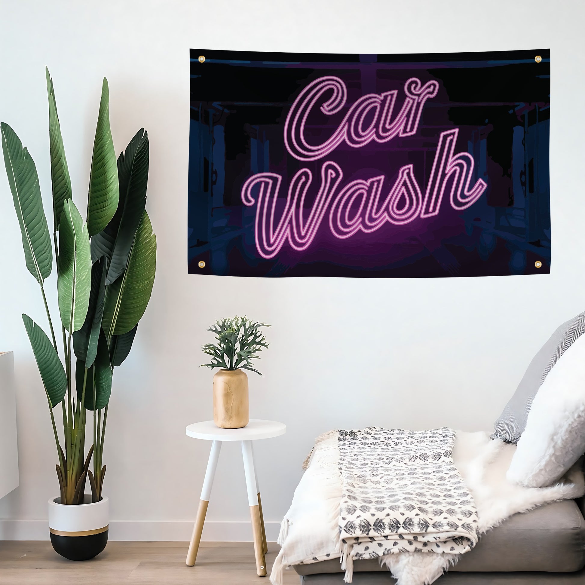 Neon-style 'Car Wash' flag banner hanging on a wall above a couch with plants and a small table.