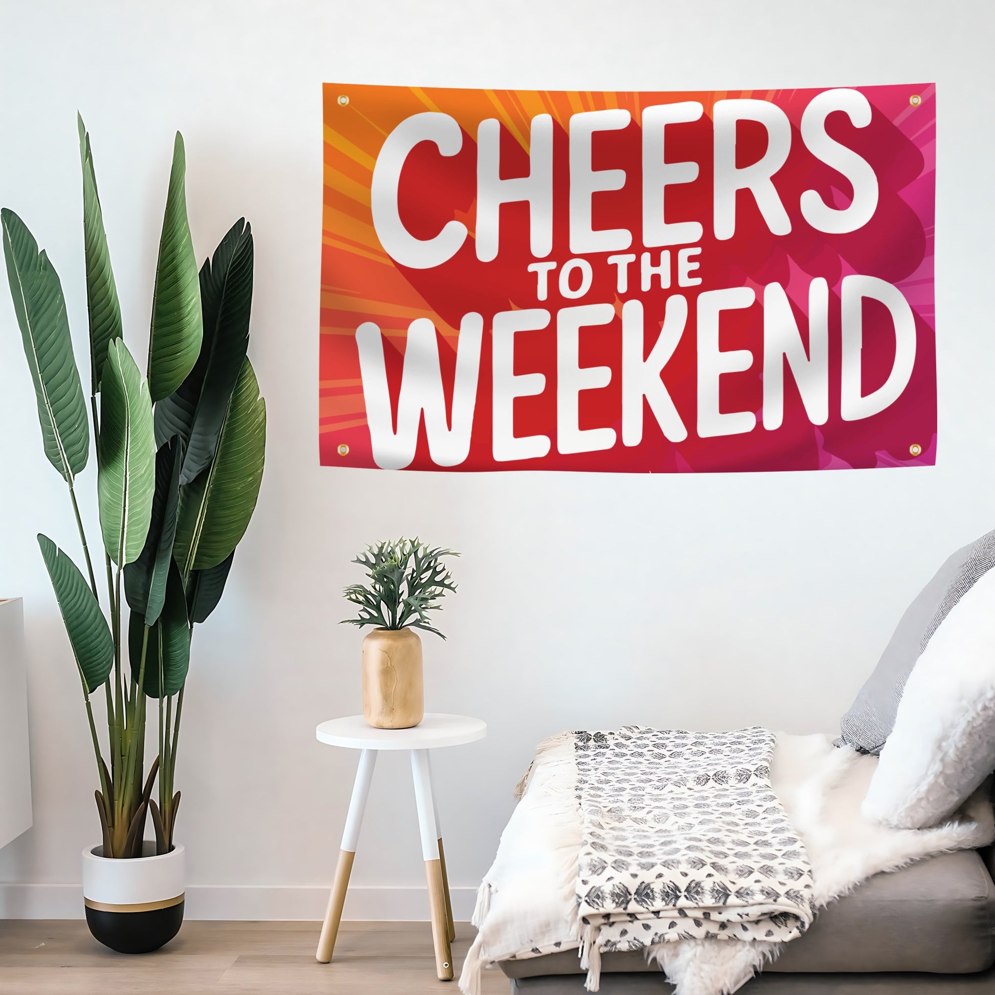 A flag banner with a red to orange gradient and the text 'CHEERS TO THE WEEKEND' in large white letters mounted on a wall.