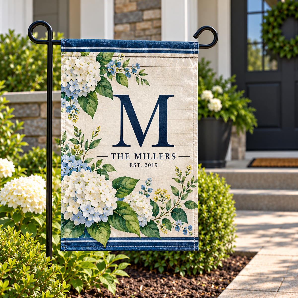 Custom garden flag with beige background, blue floral border, and large navy M monogram