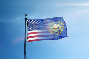 a flag flying in the wind with a blue sky in the background