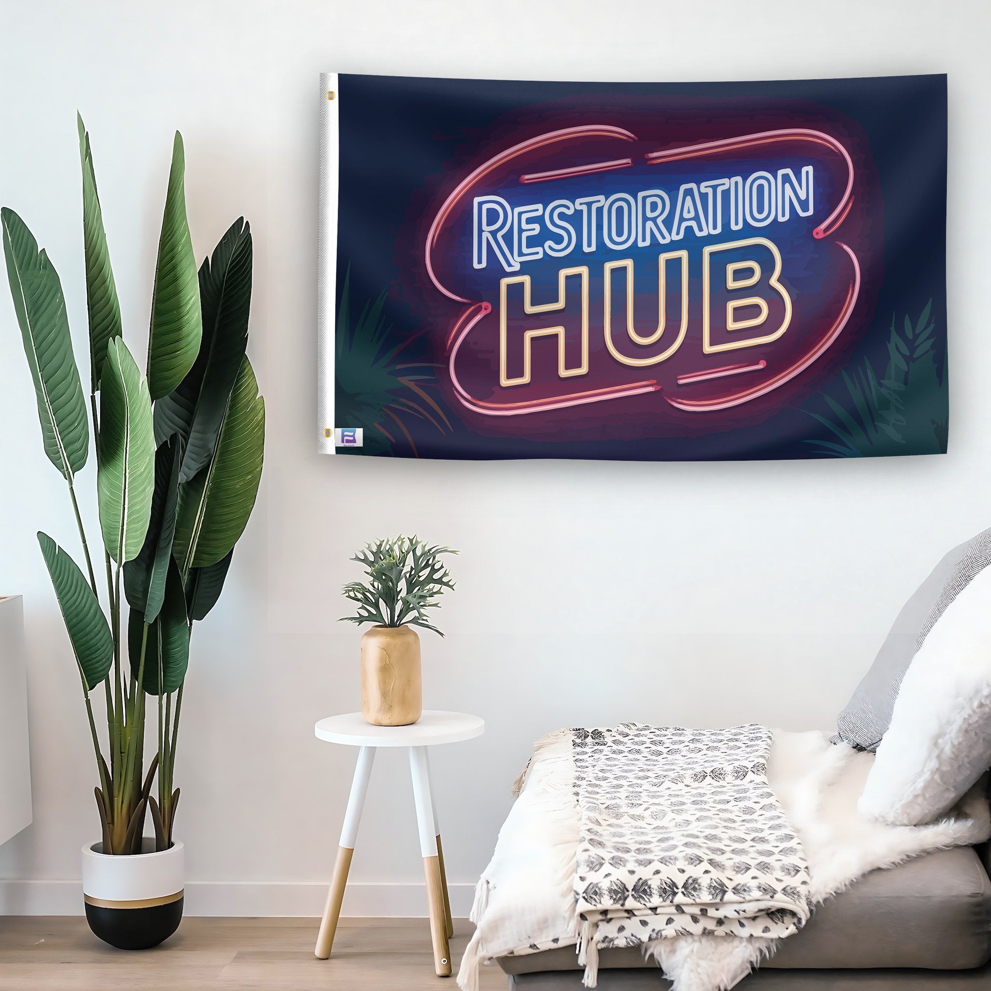 In a home setting, a flag with the saying "Restoration Hub" is mounted on a white wall by a side table.