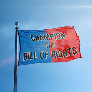 A flag containing a political slogan displayed on a high pole, featuring a patriotic red and blue background.