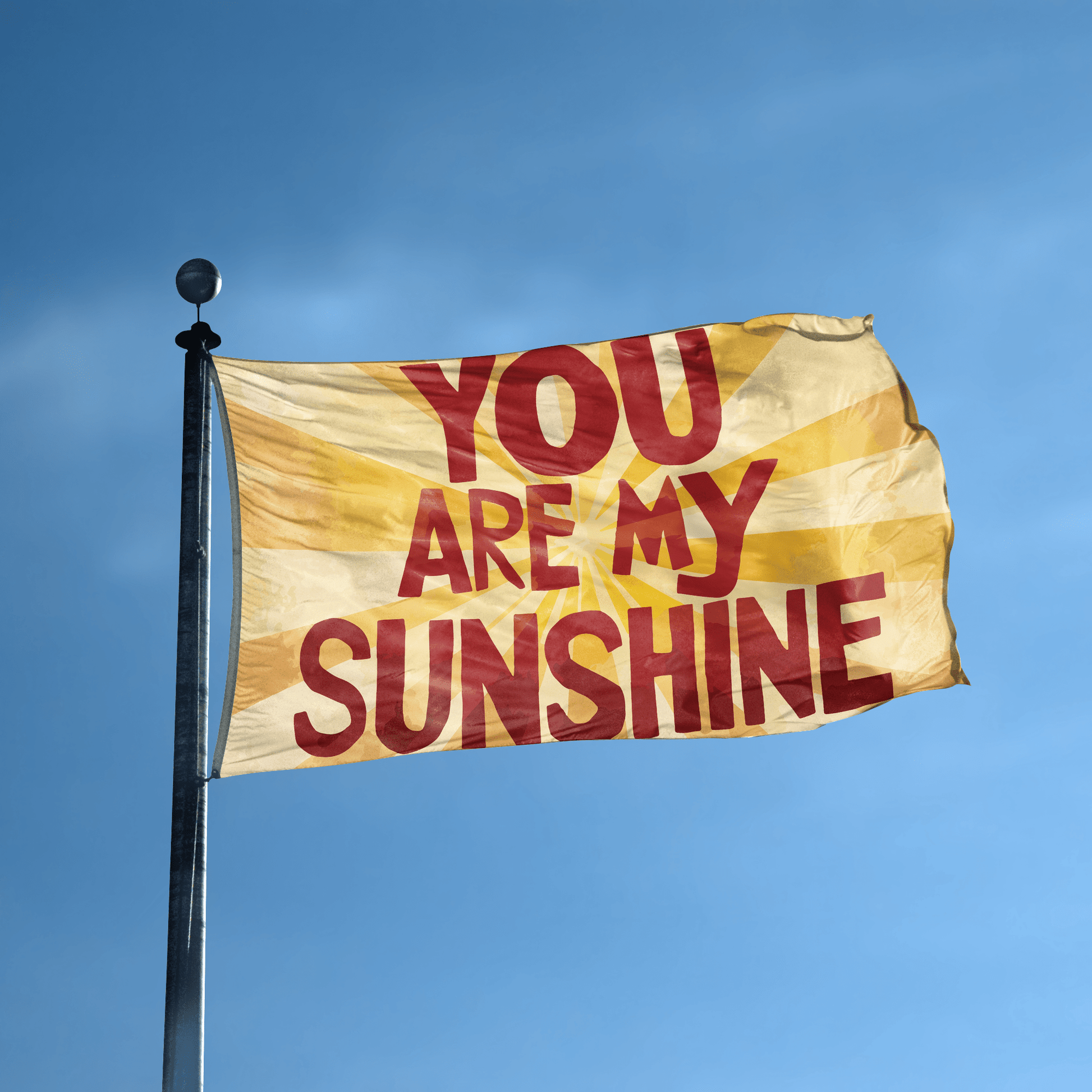 A flag with the saying "You Are My Sunshine" displayed on a high pole, with a special occasion color scheme.