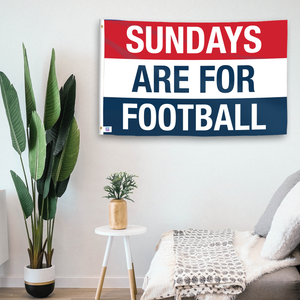 In a home setting, a flag with the saying "https://www.dropbox.com/scl/fi/x7y559y7bi05ahi2wvla0/sundays-are-for-football_room.png?rlkey=orgqpdjj6jols2kwevbiz3ei7&raw=1" is mounted on a white wall by a side table.