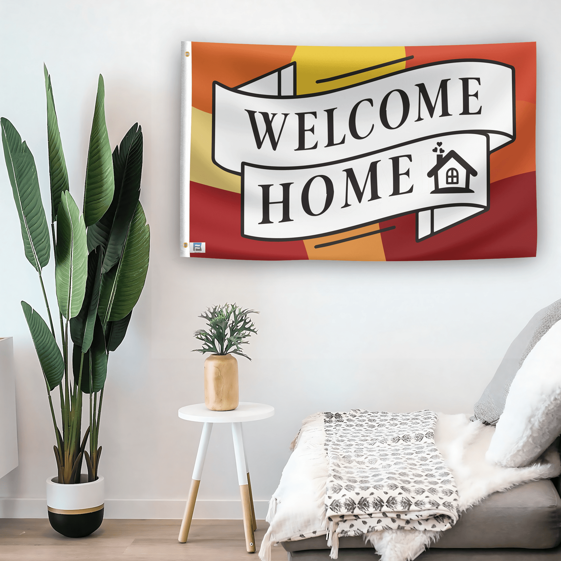 In a home setting, a flag with the saying "Welcome Home" is mounted on a white wall by a side table.