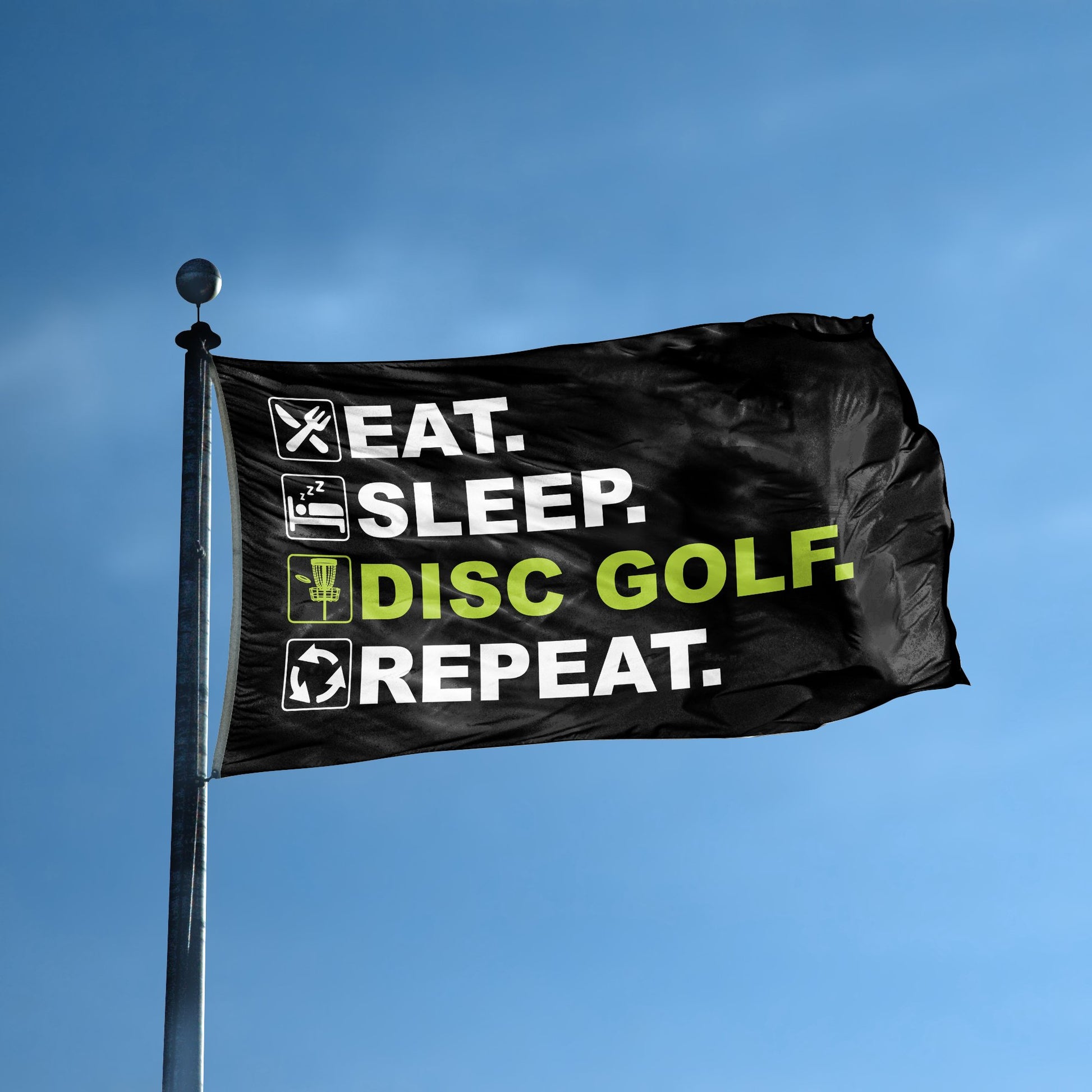 A flag with the saying "Eat Sleep Disc Golf Repeat" displayed on a high pole, with a black, white and themed color scheme.