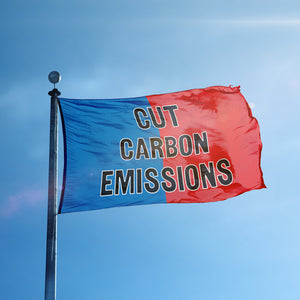 A flag containing a political slogan displayed on a high pole, featuring a patriotic red and blue background.