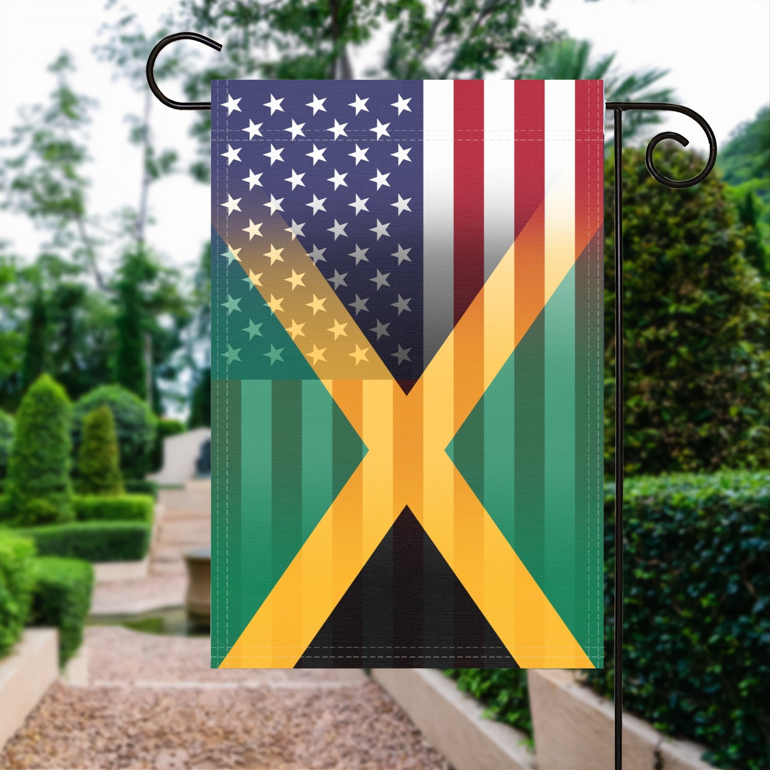 A garden flag with the Jamaican American flag design seamlessly blended with the American flag, displayed in a garden.