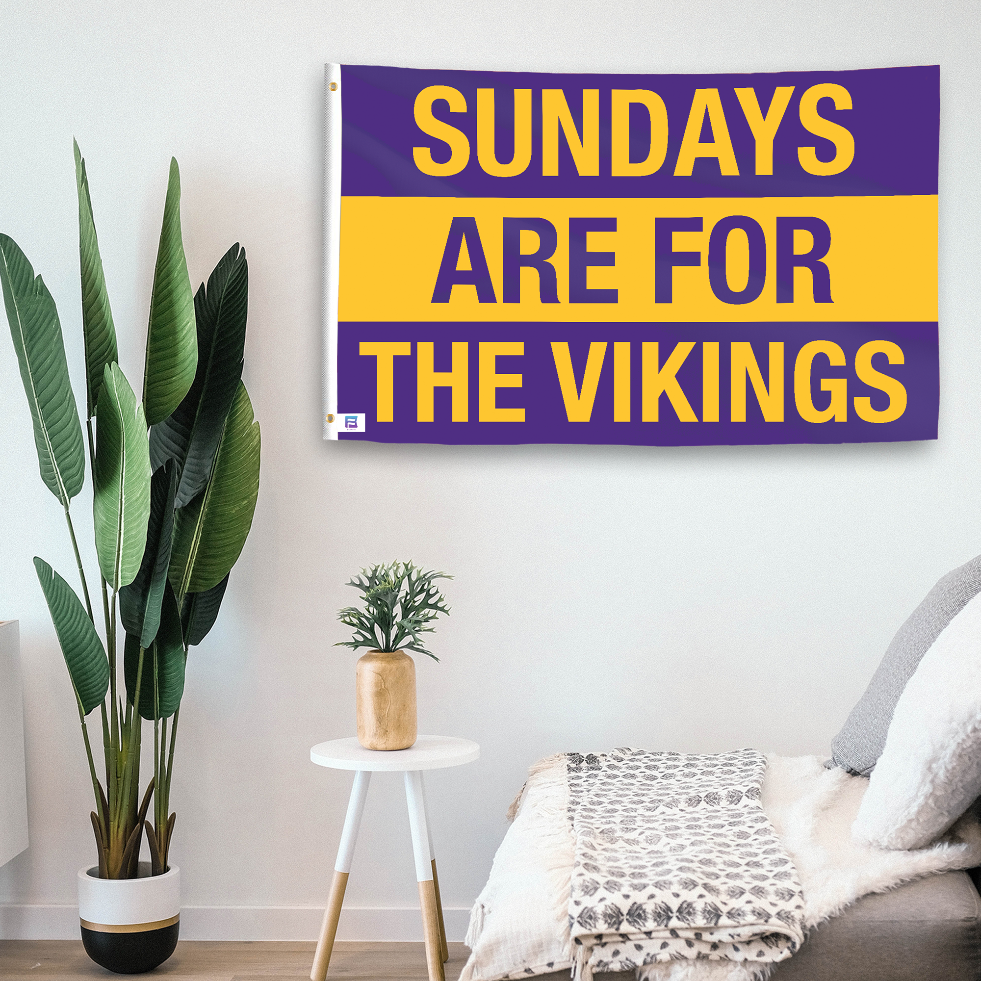 In a home setting, a flag with the saying "https://www.dropbox.com/scl/fi/8jy7uvyc5ijpsoidobc70/sundays-are-for-the-vikings_room.png?rlkey=exm7wtbnwem0ipjthrl0h8n7r&raw=1" is mounted on a white wall by a side table.