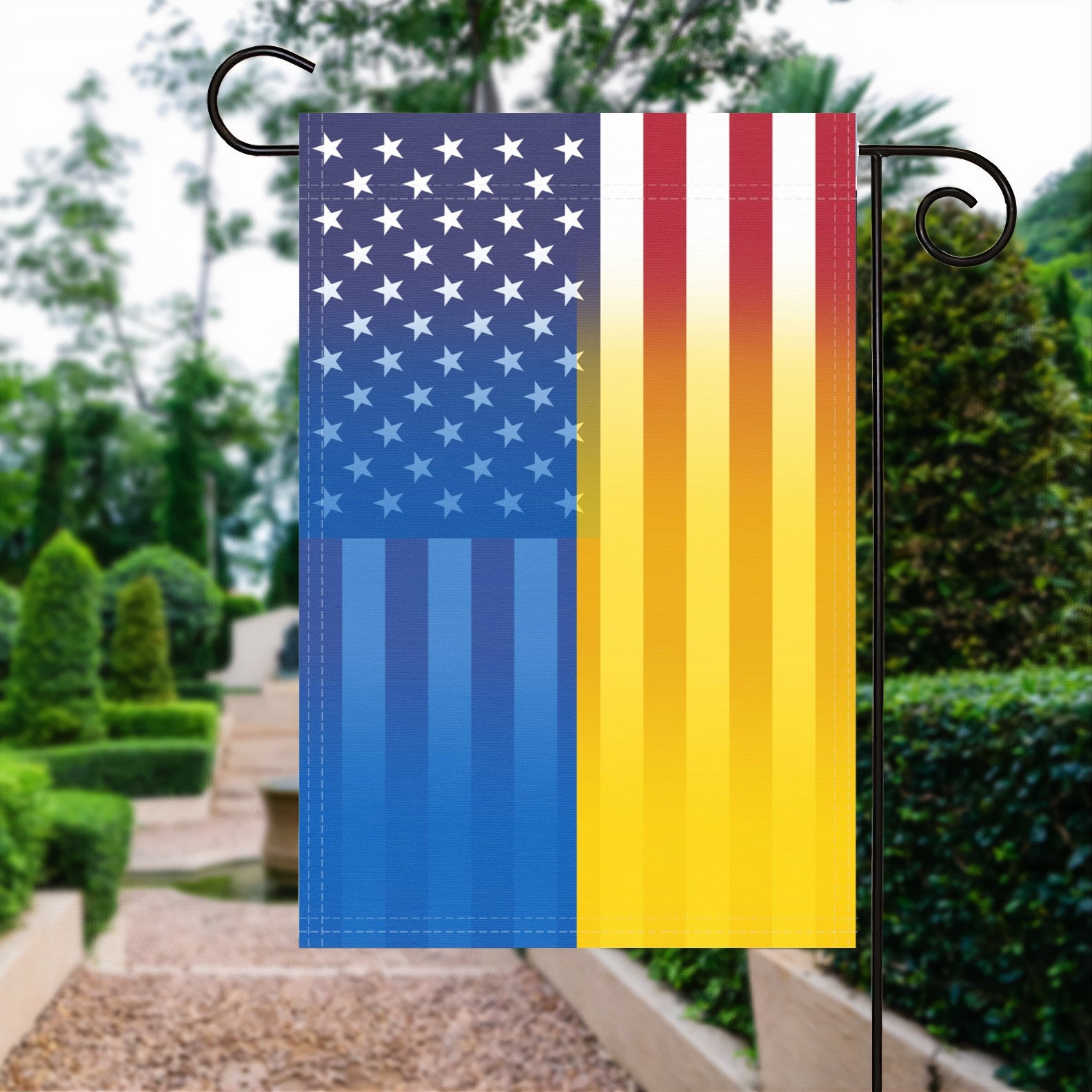 A garden flag with the Ukrainian American flag design seamlessly blended with the American flag, displayed in a garden.