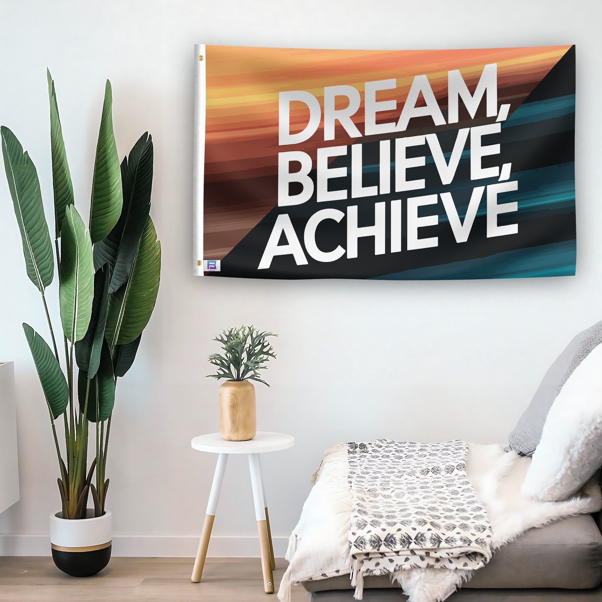 In a home setting, a flag with the saying "Dream Believe Achieve Motivational" is mounted on a white wall by a side table.