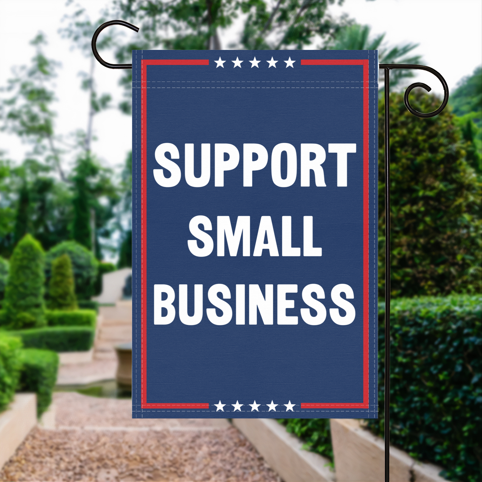 A red, white and blue political garden flag with the slogan Support Small Business.