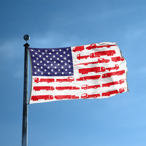 An american flag with the red stripes changed to match the theme "Truck Stripes American" displayed on a high pole.