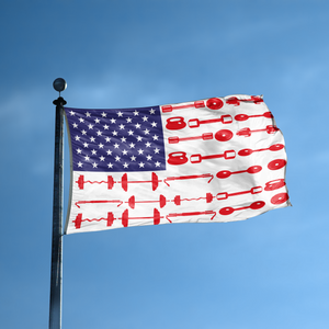 An american flag with the red stripes changed to match the theme "Weight Lifting Stripes American" displayed on a high pole.