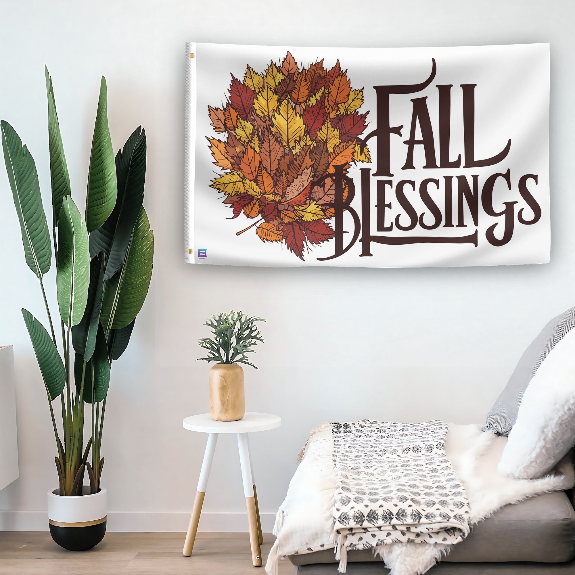 In a home setting, a flag with the saying "Fall Blessings Seasonal" is mounted on a white wall by a side table.