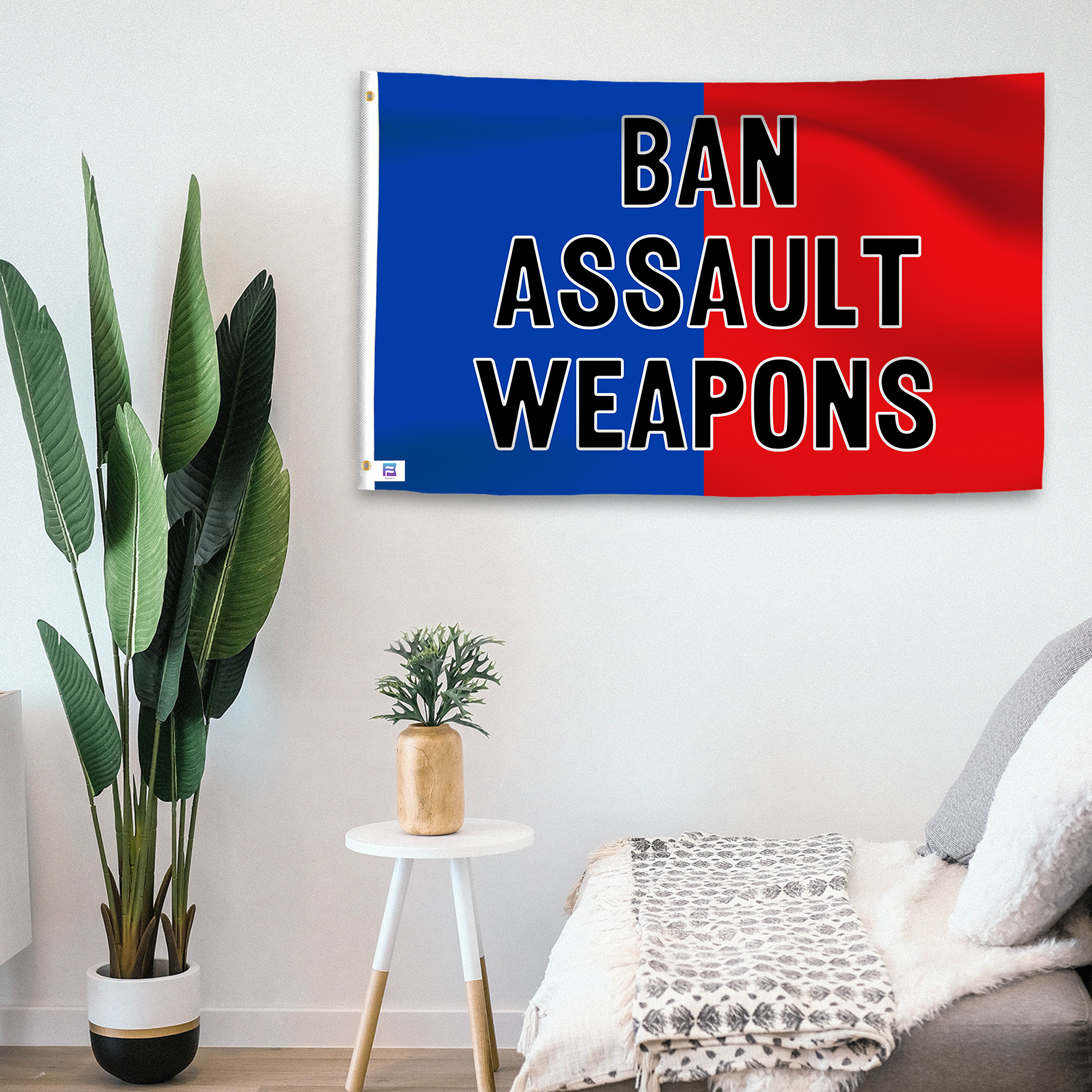 In a home setting, a blue and red flag with a political slogan is mounted on a white wall by a side table.