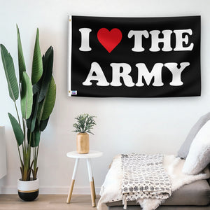 In a home setting, a flag with the saying "I Love The Army" is mounted on a white wall by a side table.