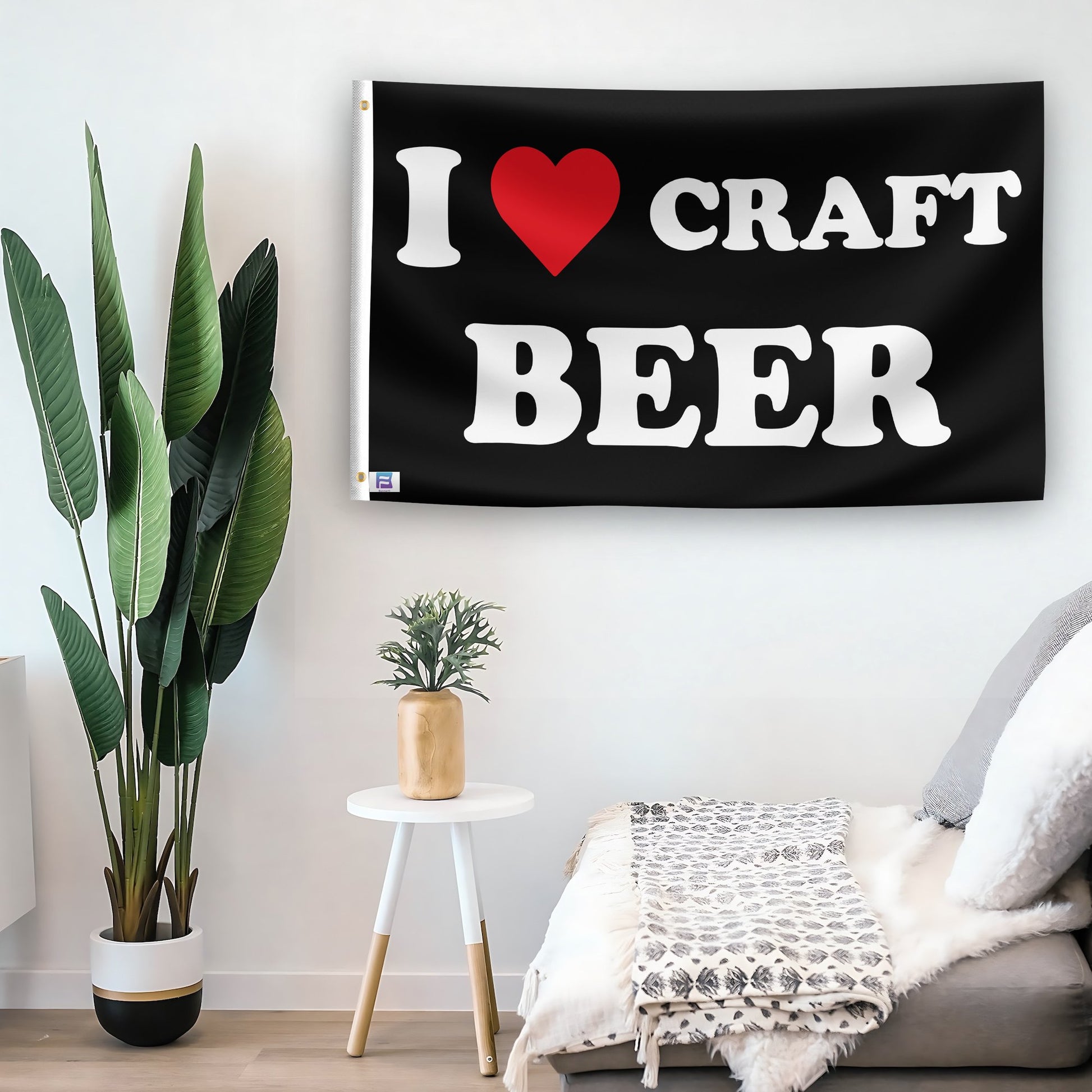 In a home setting, a flag with the saying "I Love Craft Beer" is mounted on a white wall by a side table.