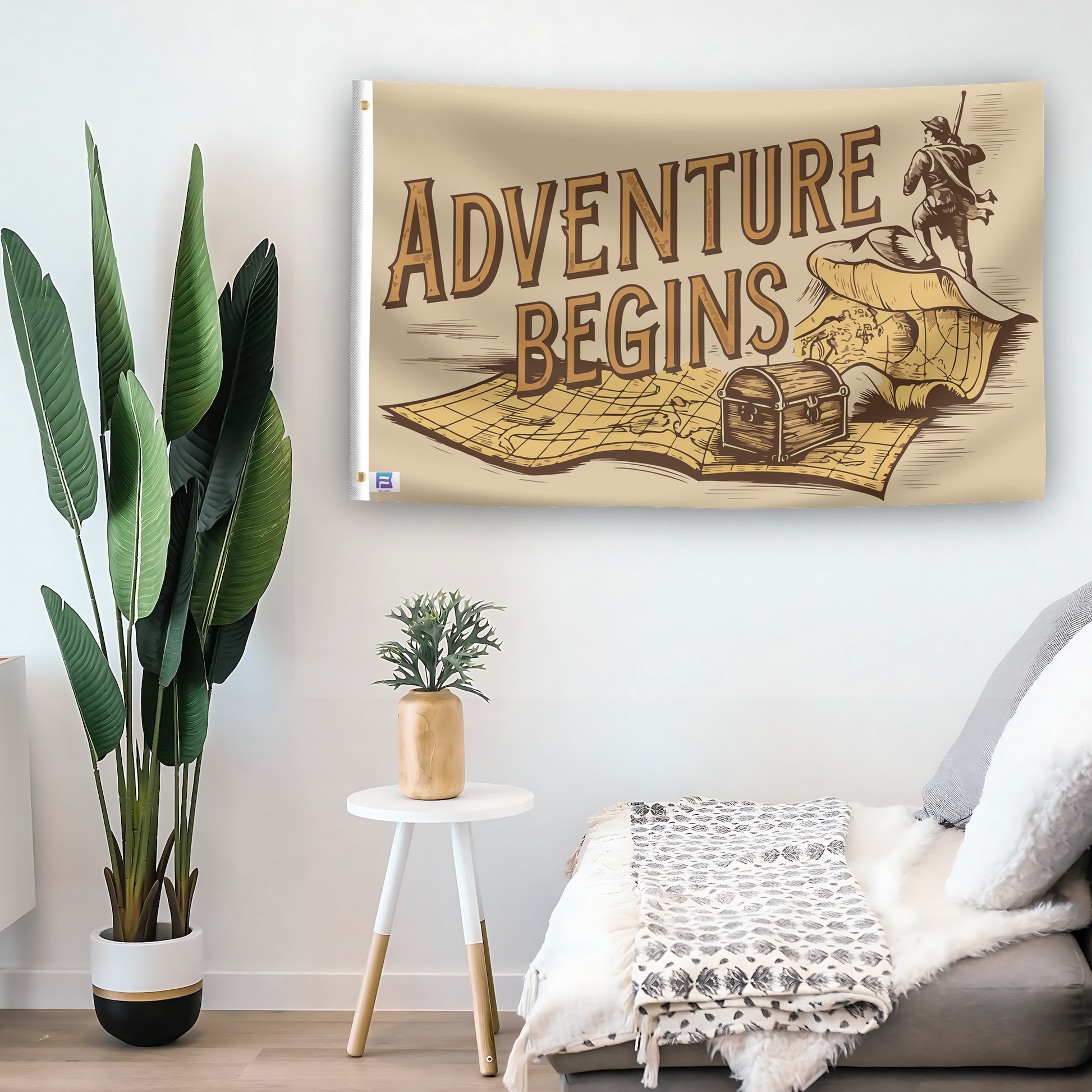 In a home setting, a flag with the saying "Adventure Begins" is mounted on a white wall by a side table.