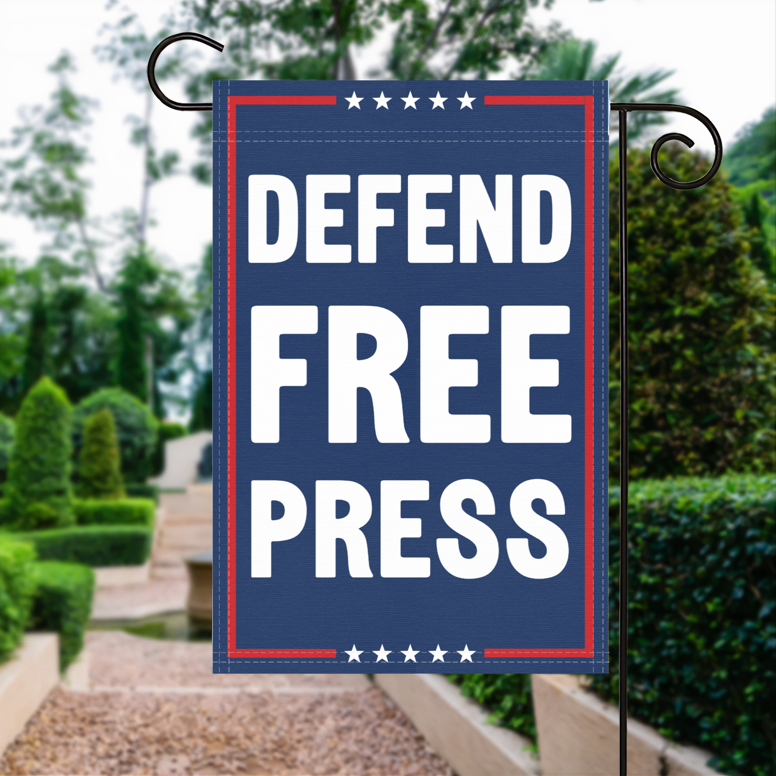 A red, white and blue political garden flag with the slogan Defend Free Press.