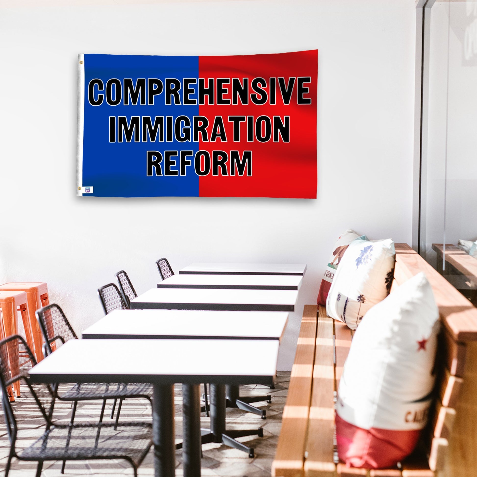 A political flag in royal blue and crimson red with a political statement on a wall in a cafe setting.