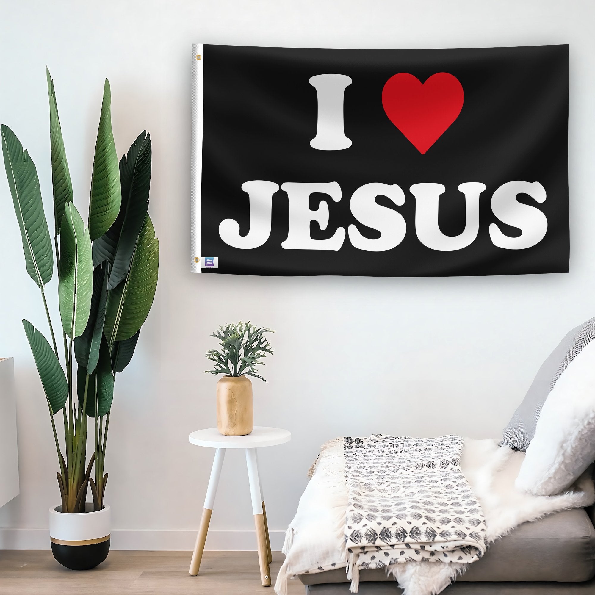 In a home setting, a flag with the saying "I Love Jesus" is mounted on a white wall by a side table.