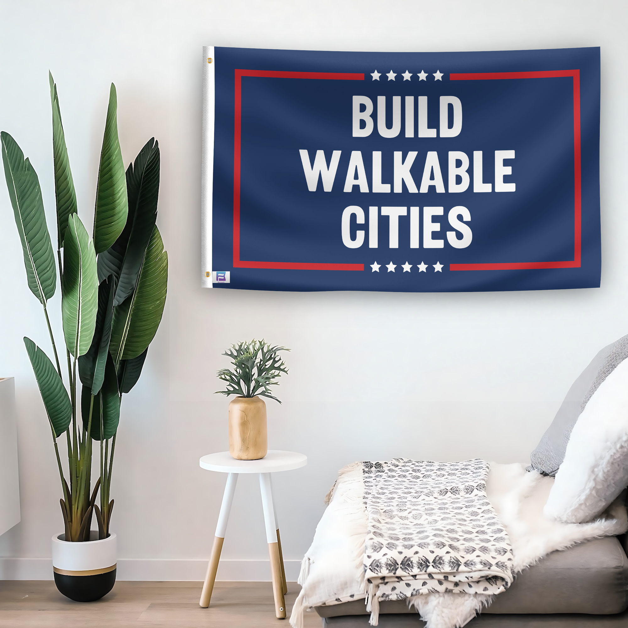 In a home setting, a flag with the saying "Build Walkable Cities Political" is mounted on a white wall by a side table.