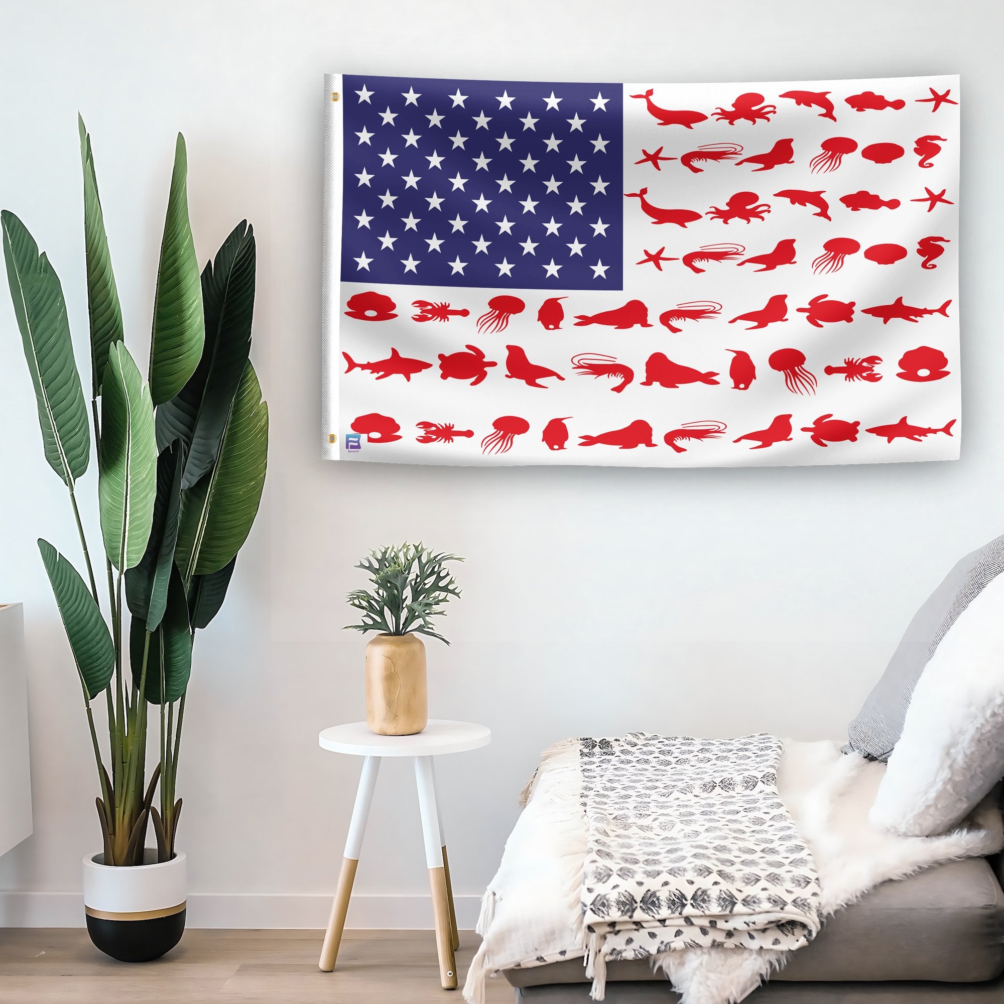 In a home setting, an american flag with the theme "Marine Animals Stripes American" is mounted on a white wall by a side table.